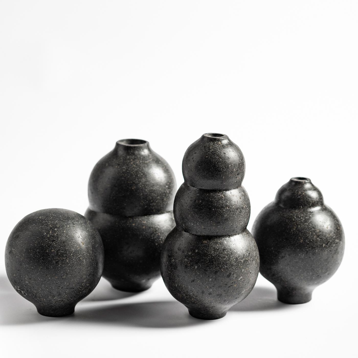 Part of the Tarsie Geometriche collection, this set of 4 fine vases is made of black lava stone with a honed finish. The three-dimensional profile is composed of elegantly piled globes, supported by a small round foot. The four vases (110 x 160 mm,