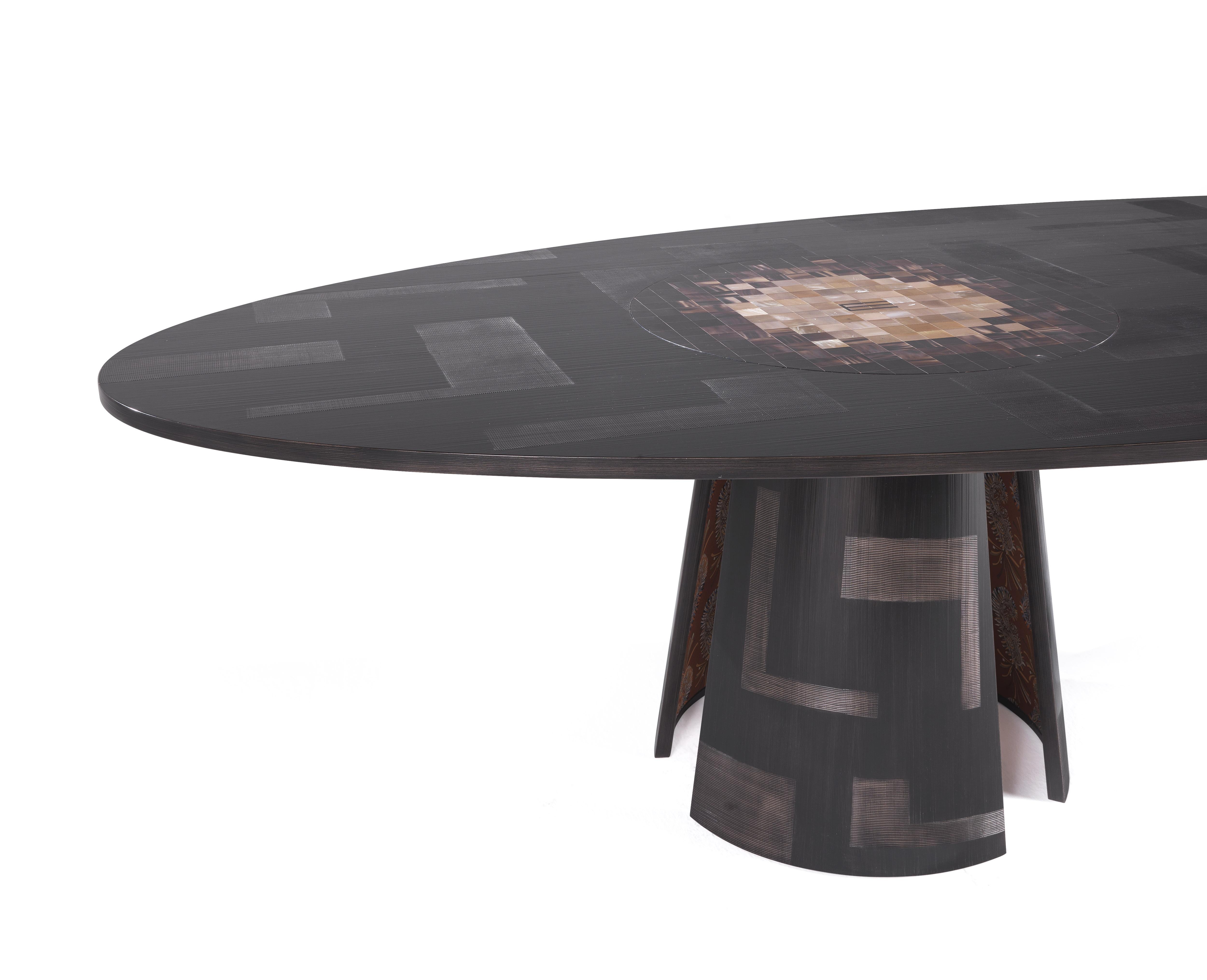 An imposing table of ethnic inspiration. The structure in glossy dark wengé with spatula finish lends the table a rough effect while the top characterized by the presence of an ox horn inlay recreating a mosaic pattern reminds of the Mesopotamic