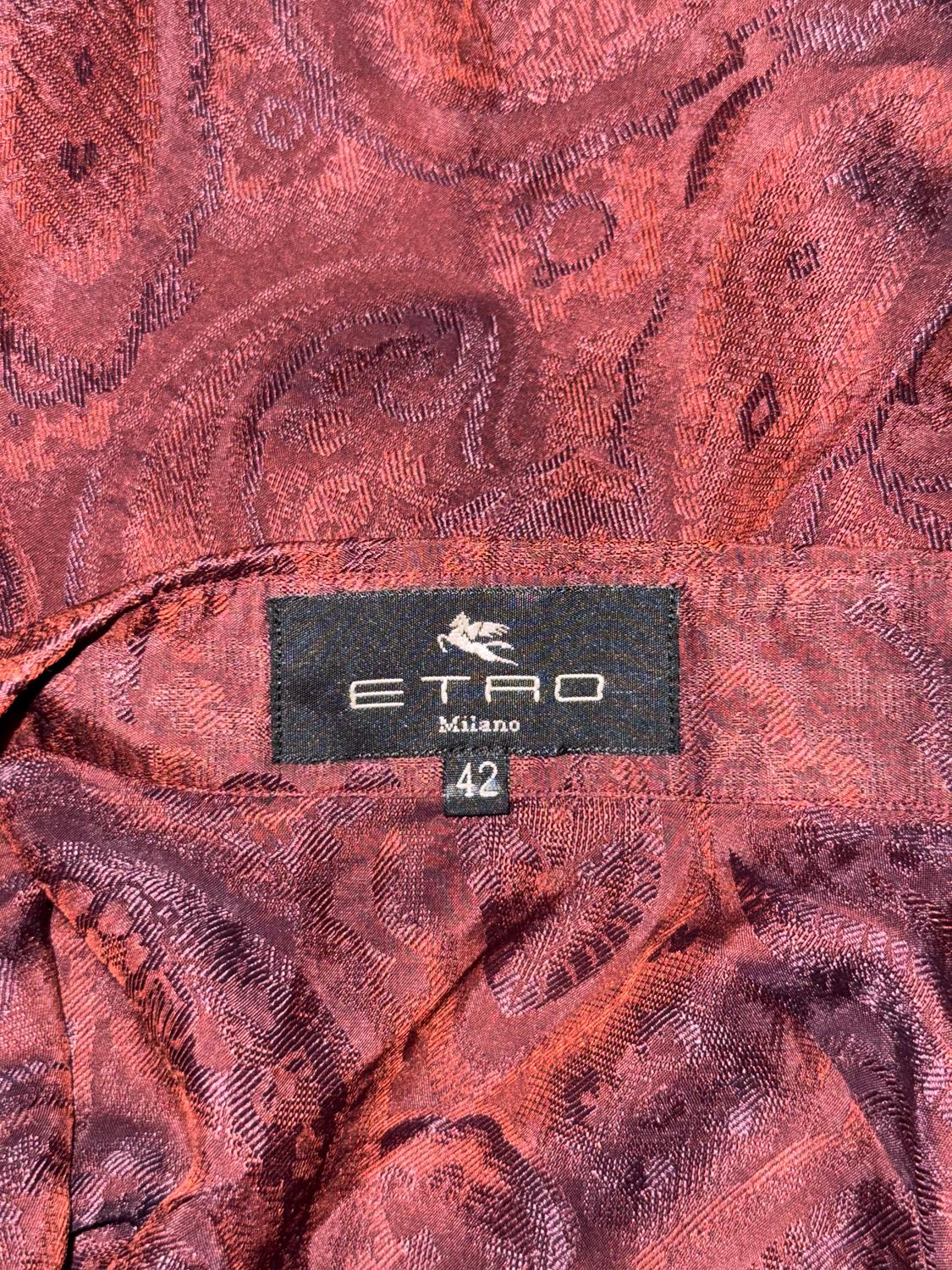 Una blusa estupenda para otoño o invierno de Etro. En un maravilloso color berenjena, la blusa está confeccionada en un tejido texturizado que es una mezcla de acetato y seda.  Tiene cuello de pico, abertura delantera con botones y puño con un solo