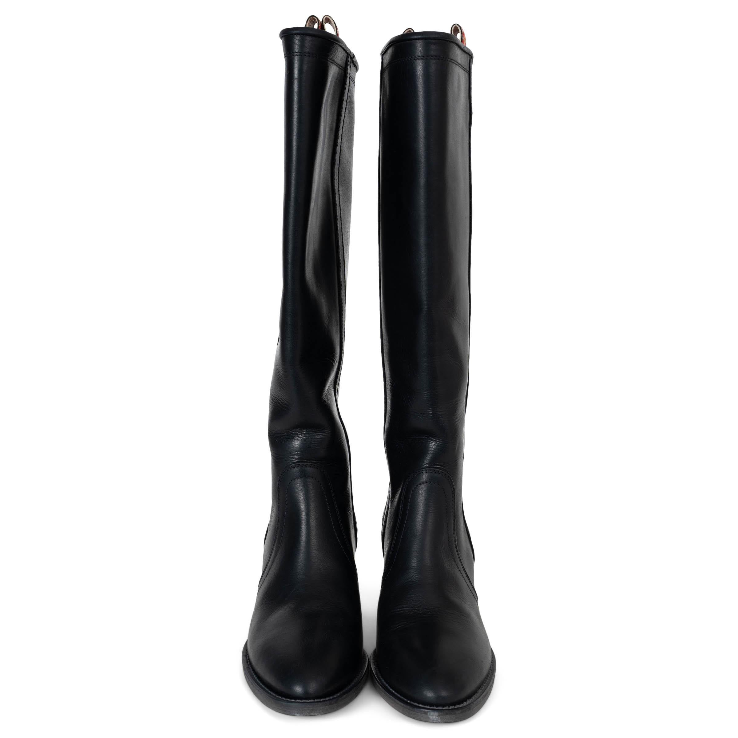 This 100% authentic Etro cowboy boots in black leather embody timeless Western craftsmanship with a refined edge. Featuring intricate western carving above the heel, they are designed with a knee-high shaft, pointed toes, and classic Cuban heels. A
