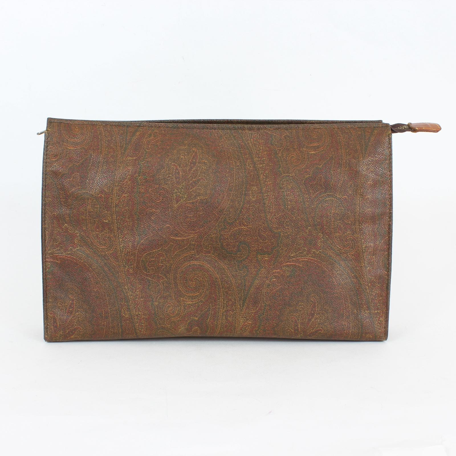 Etro clutch bag vintage 90s. Brown handbag with typical paisley pattern. Rigid canvas fabric zip closure. Made in Italy. The dust bag is present. The bag is in excellent condition on the outside, but on the inside it is a little cracked.

Height: 25