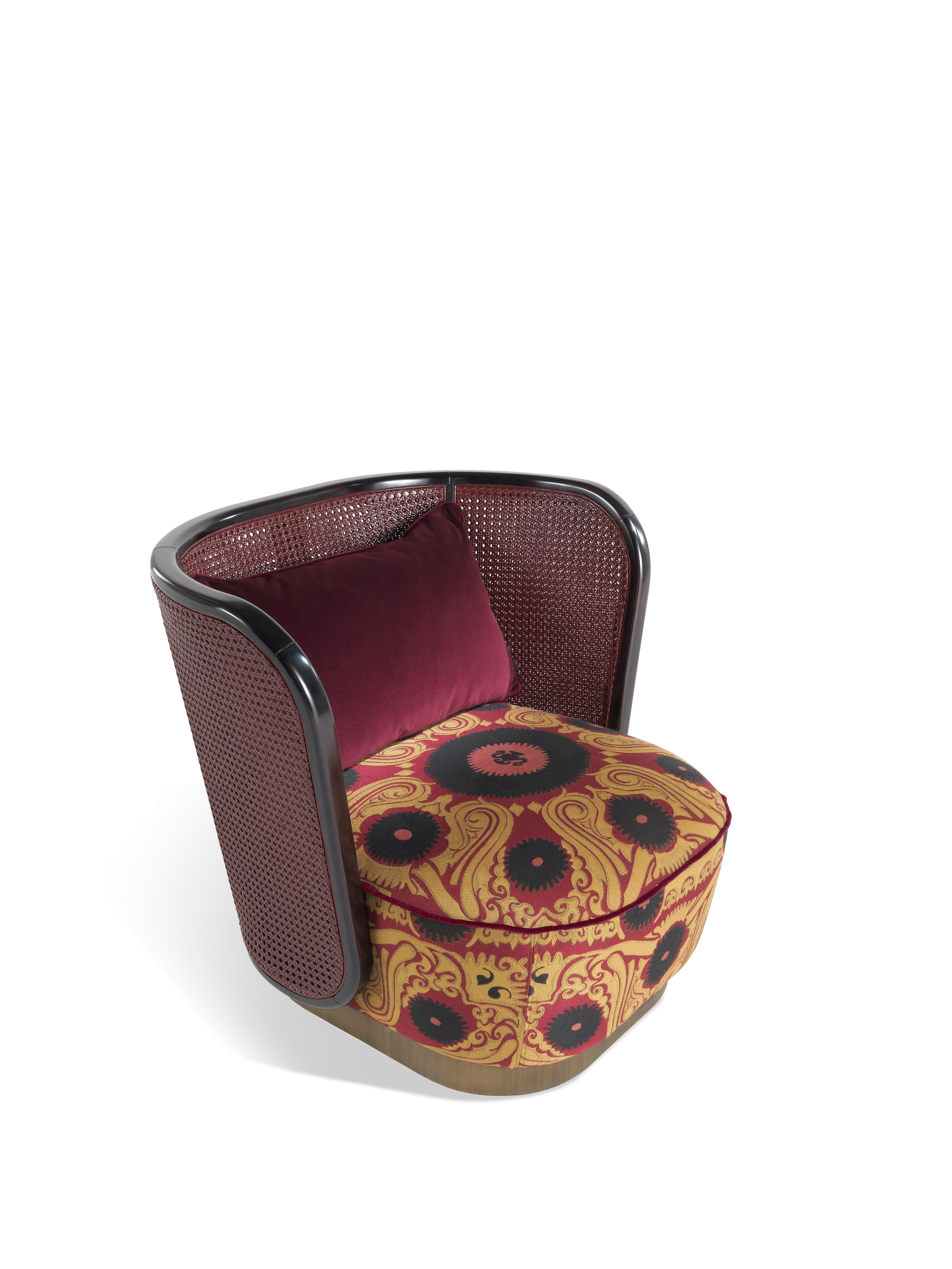 An armchair with soft and enveloping lines, whose low and comfortable seat recalls in the shape the exoticism of a traditional ottoman. The upholstery in jacquard fabric Bukhara with Suzani pattern creates a harmonious contrast with the lightness of