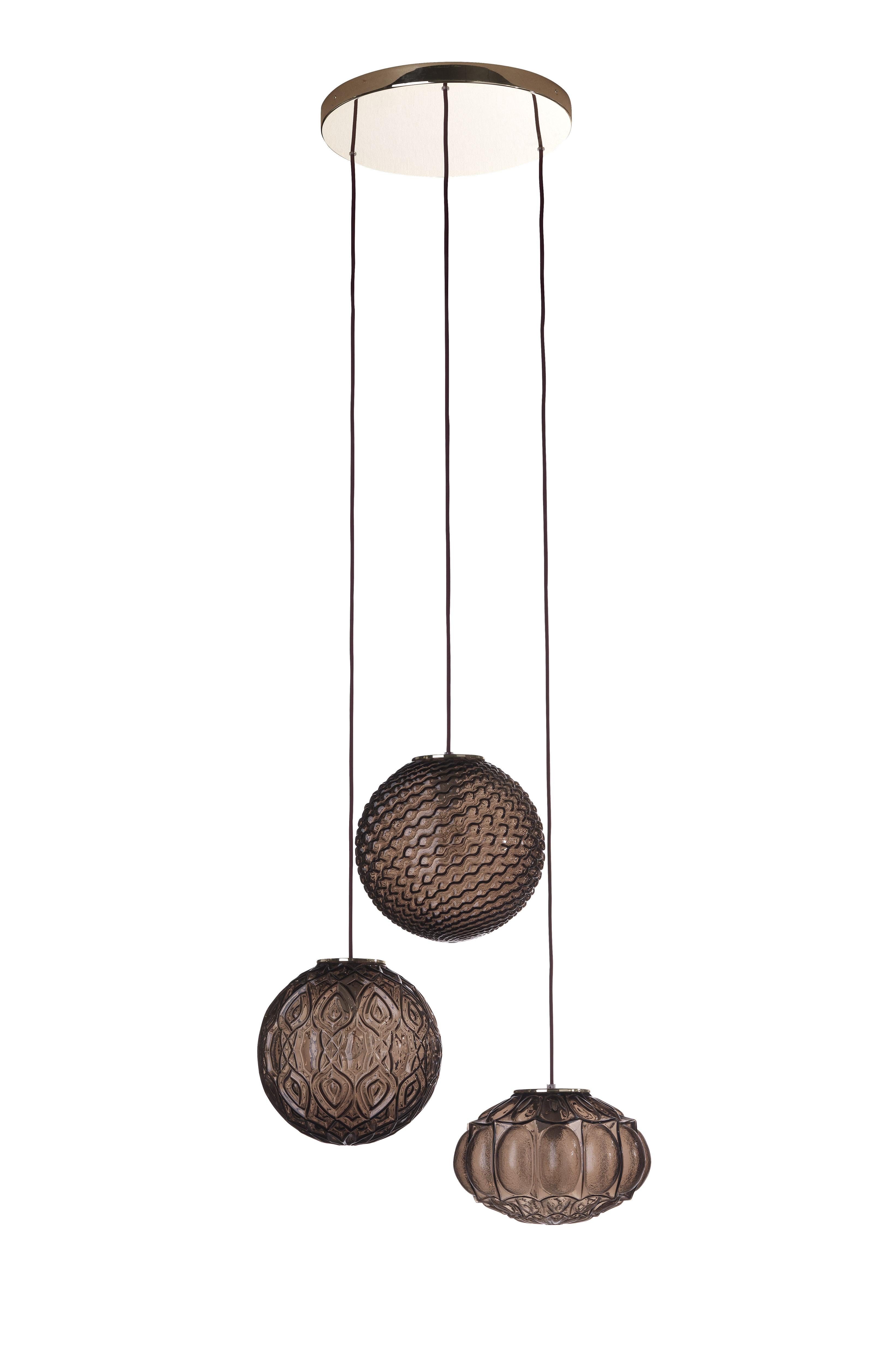 CHAGALL 3-Licht-Kronleuchter mit Schirmen aus mundgeblasenem, klarem Bronzeglas. Kabel aus bordeauxfarbenem Stoff. Deckenrosette in Goldausführung.