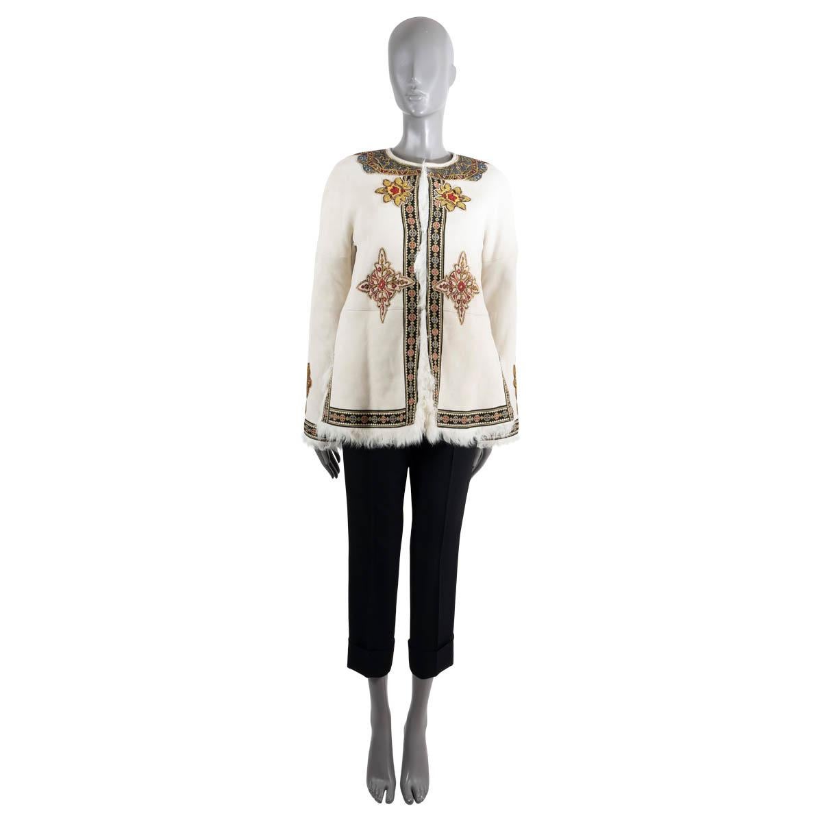 100% authentic Etro Mustang jacket in cream lambskin leather. Features ornate multicolor bohemian embroidering, round collarless neck, dropped shoulder and fur trims. Closes with concealed hook and eye closure on the front and and is fully lined in