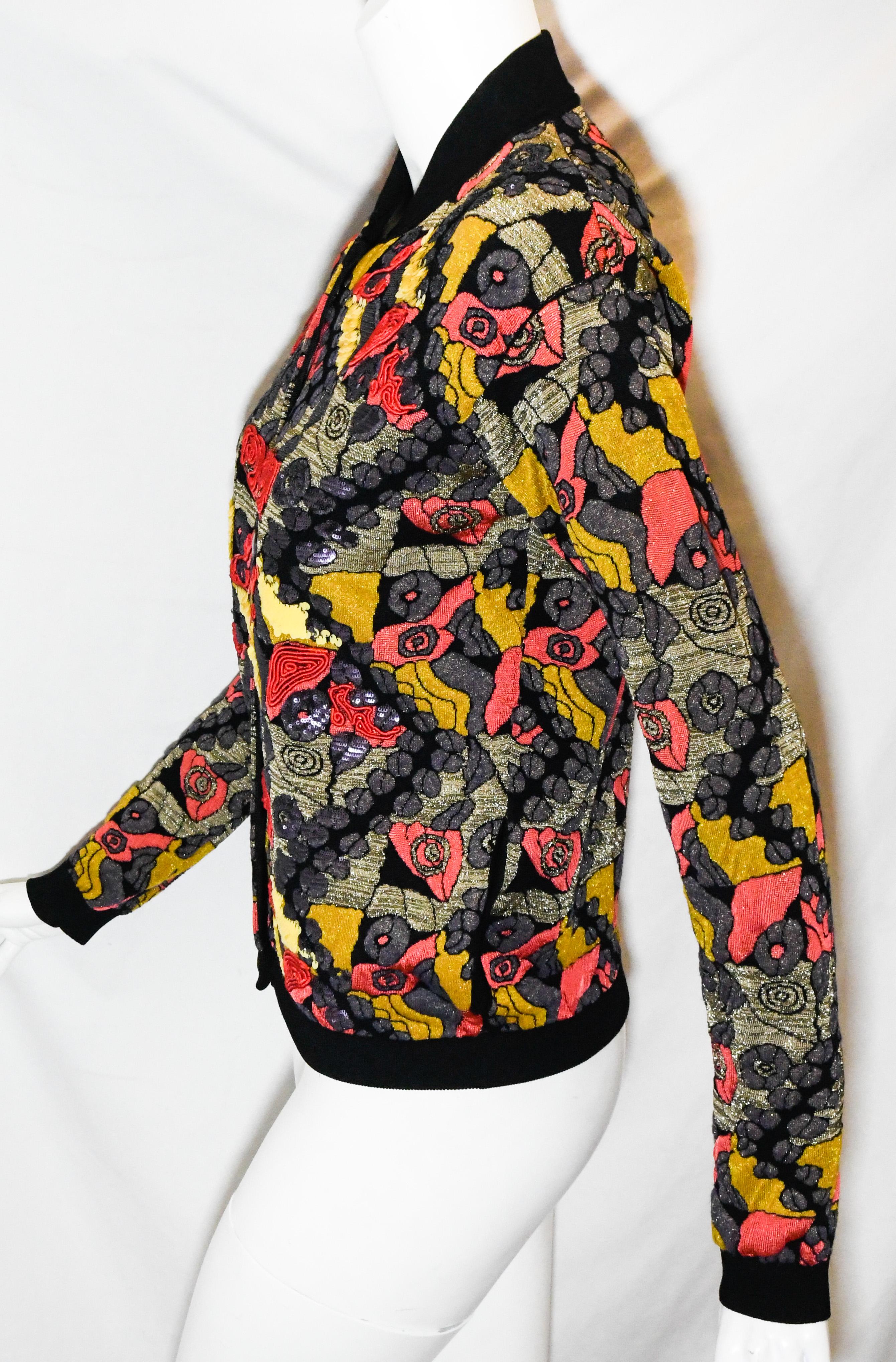 Etro casual bomber style jacket is a must for any collector.  Features black, red, purple and yellow floral pattern allover with gold metallic thread accents, banded collar and cuffs, 6 antiqued front buttons.  Extensive, dimensional paillette