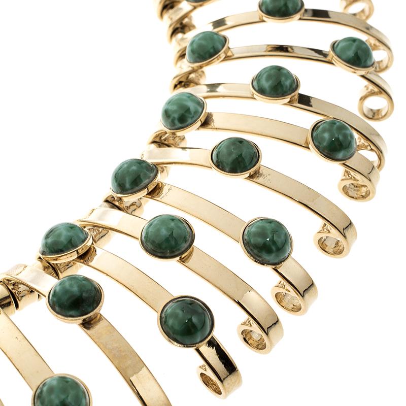 Chokers are back in fashion today and have become one of the most celebrated piece of jewellery in its new avatar. This choker by by Etro comes in a binder design in a gold tone metallic body. The green carbochron parts add colour and design to this
