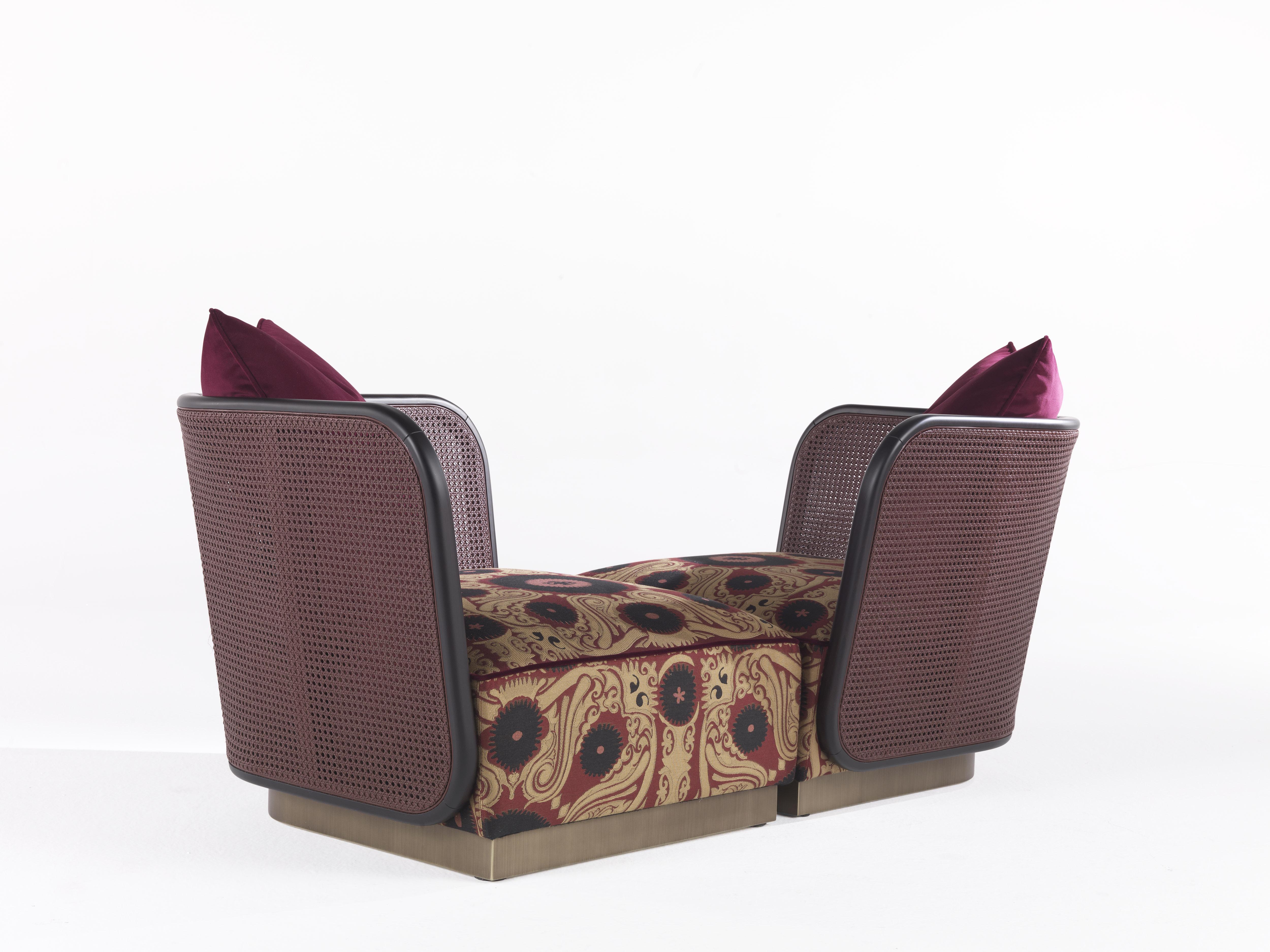 A pair of armchairs with soft and enveloping lines, whose low and comfortable seat recalls in the shape an exotic traditional ottoman. The upholstery in jacquard fabric Bukara with Suzani pattern creates a harmonious contrast with the lightness of