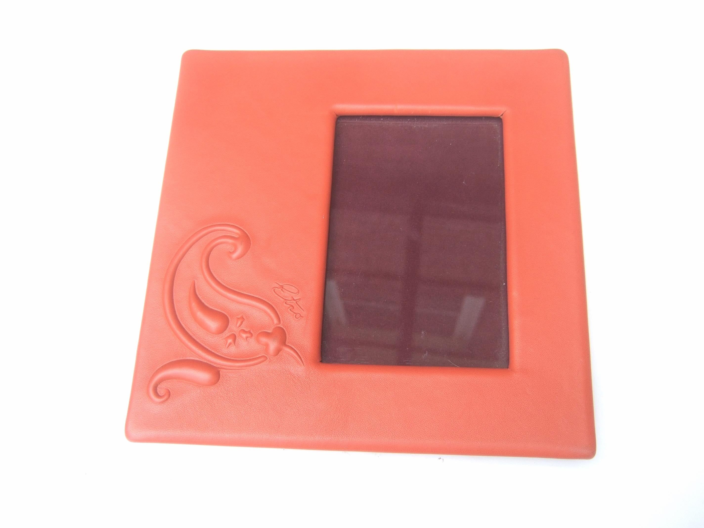 Etro Italian orange leather photo frame c 21st 
The stylish picture frame is designed 
with smooth tangerine color orange leather

One of the bottom corners has a raised 
leather paisley swirl design with Etro's script
 name. The glass display