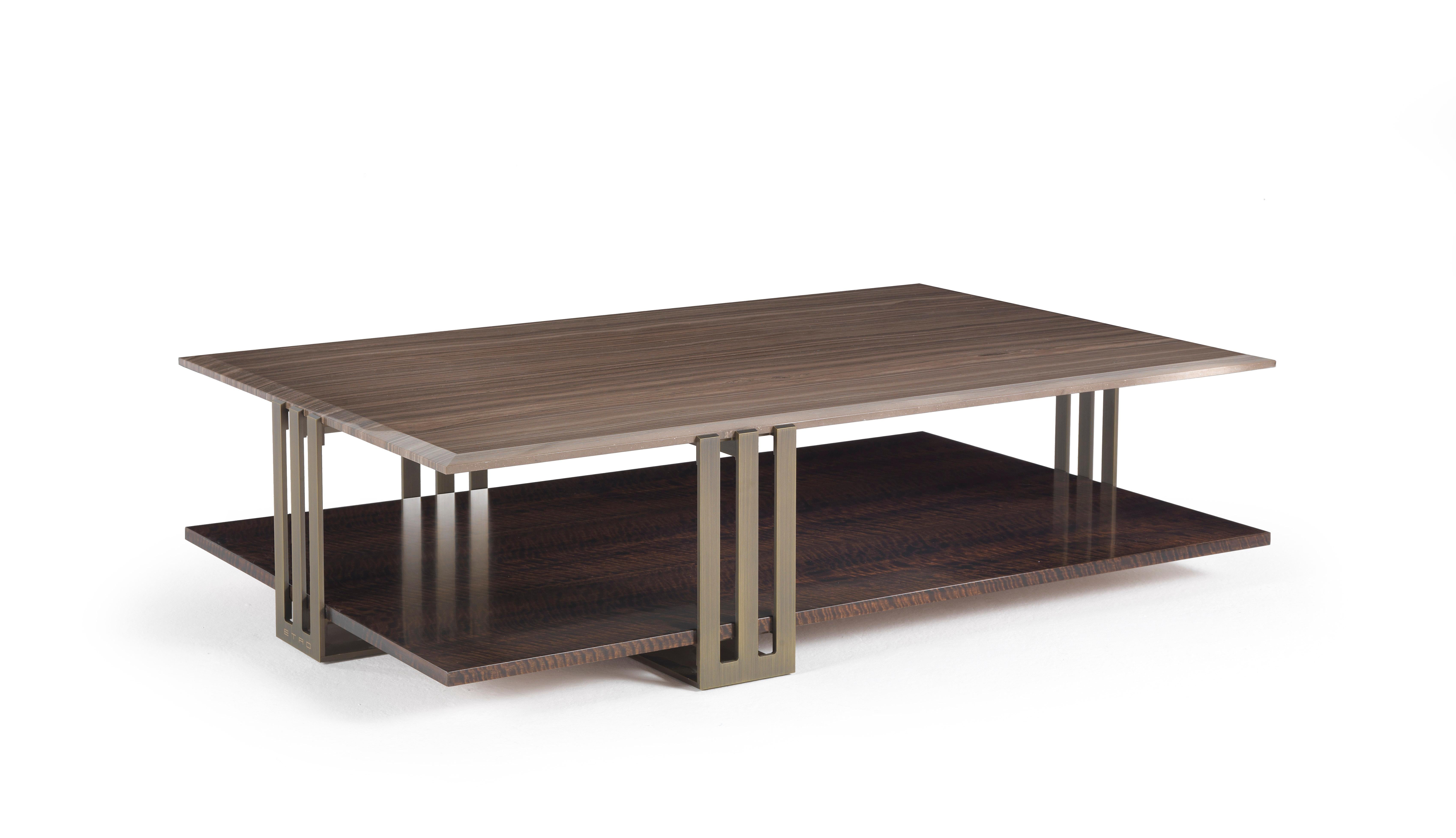 Ein kompakter Tisch mit zwei Platten, der sich durch eine originelle Kombination von Materialien auszeichnet. Die Struktur aus patinierter Bronze trifft auf die kostbare Eleganz der Platten aus Marmor oder Holz aus der Kollektion Etro Home