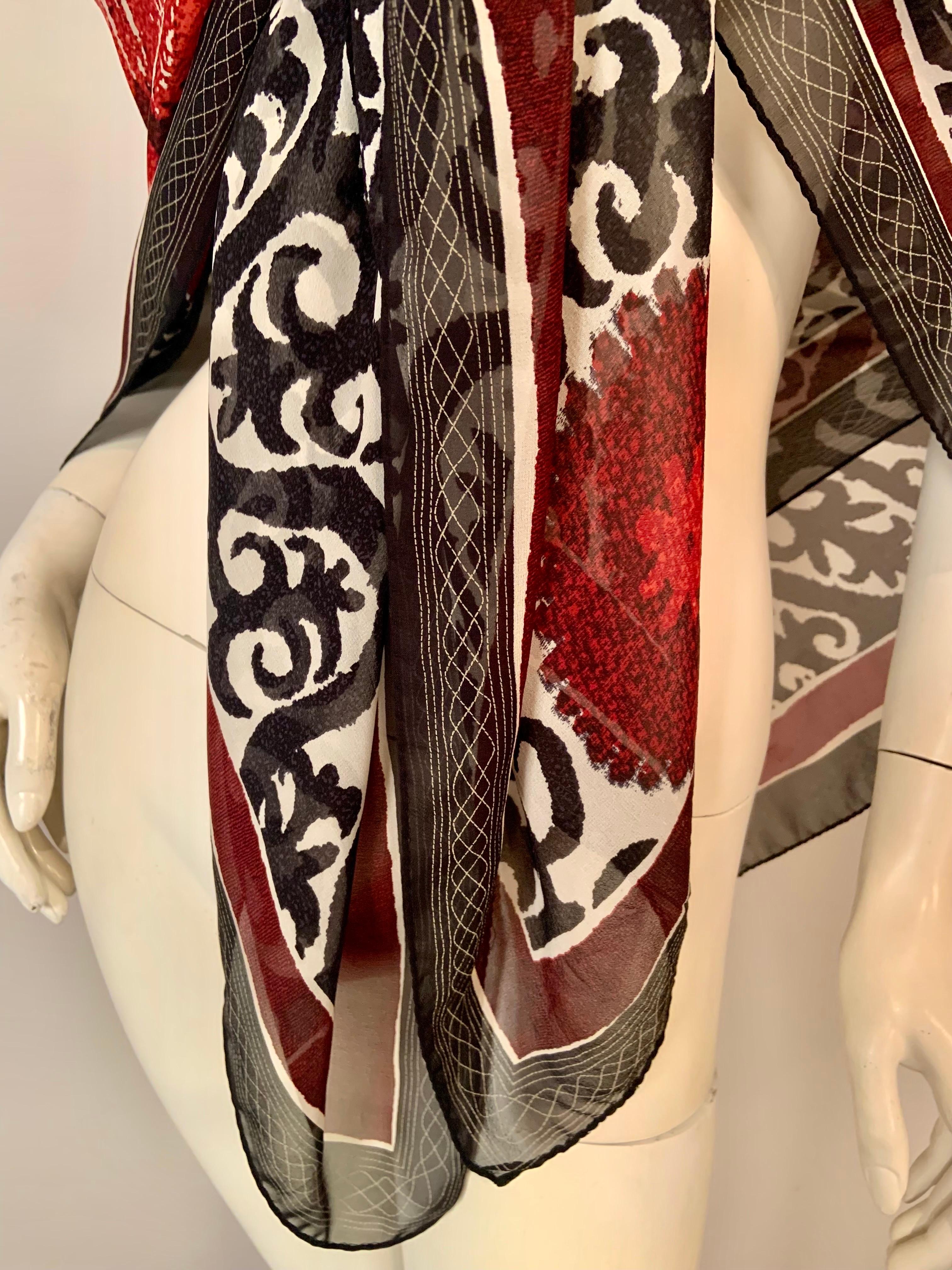 Questo delizioso scialle in chiffon di seta di grandi dimensioni di Etro presenta un disegno a scorrimento in nero su sfondo bianco che ricorda i lavori in ferro di una casa di New Orleans.  Disegni circolari rossi di varie dimensioni sono sparsi