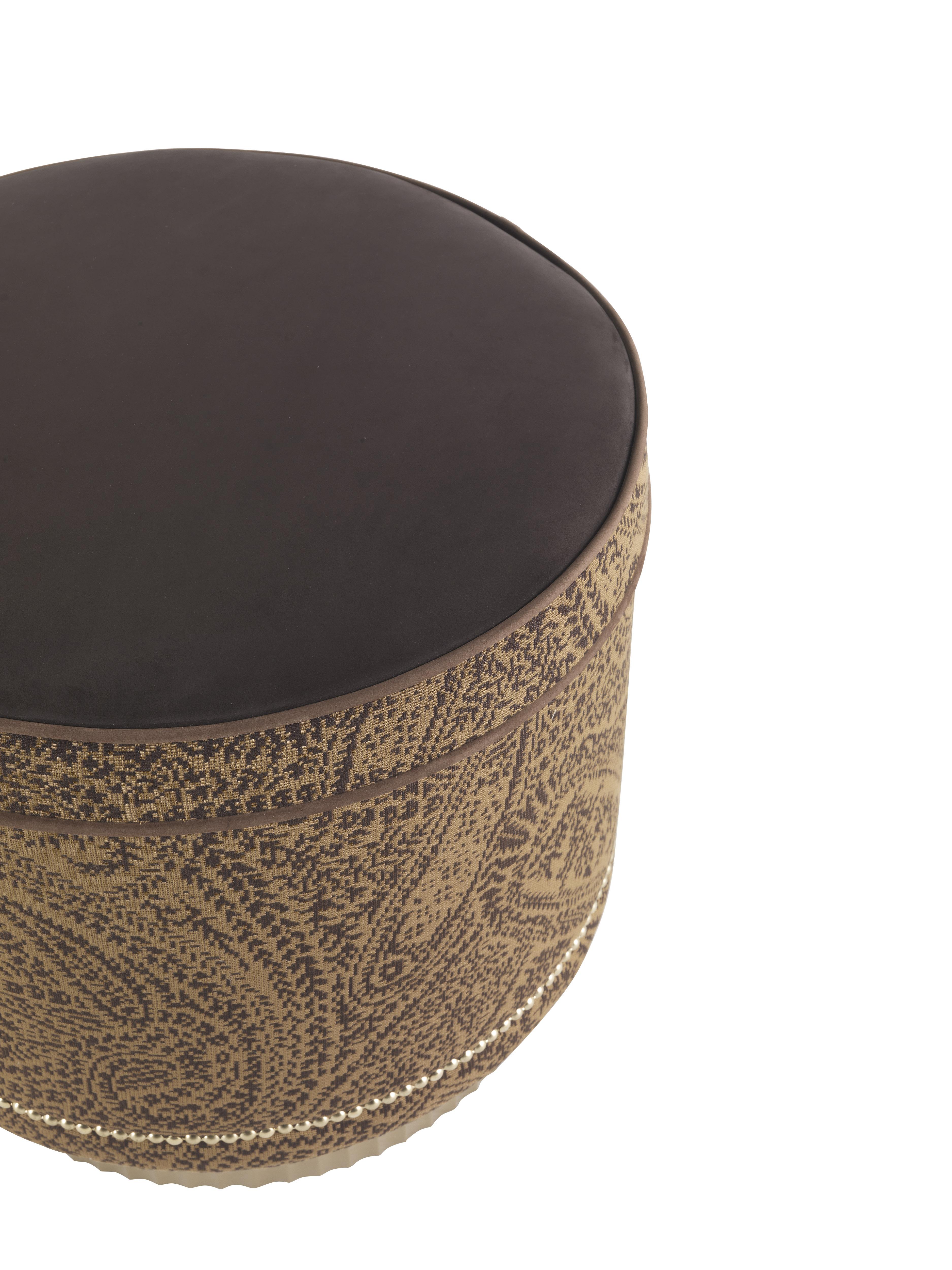 MERIAM Pouf with Structure in wood and foam. Sides in fabric cat. A Zulu col. 1 Tobacco. Seat leather cat. A Nuuk col. 1 Brown. Piping leather Nuuk col. 3 Nut. Ornamental golden nails on the bottom. Pleated base in gold lacquered wood.