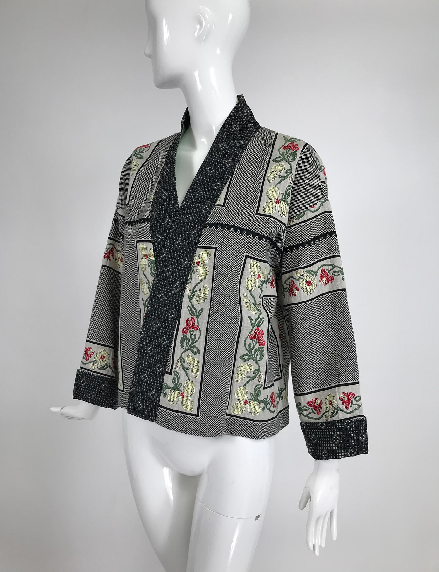 Etro mix print kimono jacket, with a band facing, wrap front and full straight sleeves. The jacket is a mid weight textured fabric similar to brocade, in a mini black & white design, surrounded with a border of trailing flowers. the front facing and