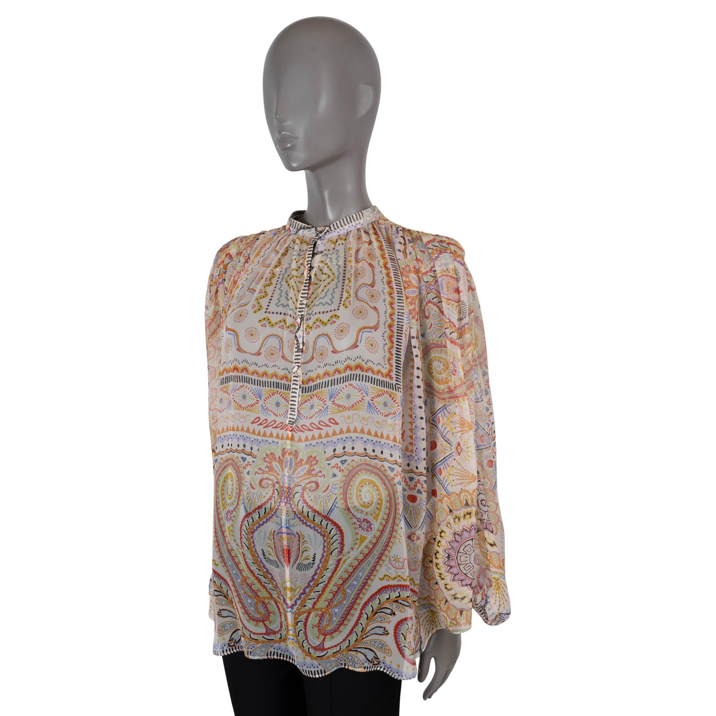 100% authentic Etro peasant blouse in white chiffon silk (100%) with multicolor paisley print. Features a A-line silhouette with pleating on the shoulders, band collar and long puff sleeve with buttoned cuffs. Opens partially with fabric covered