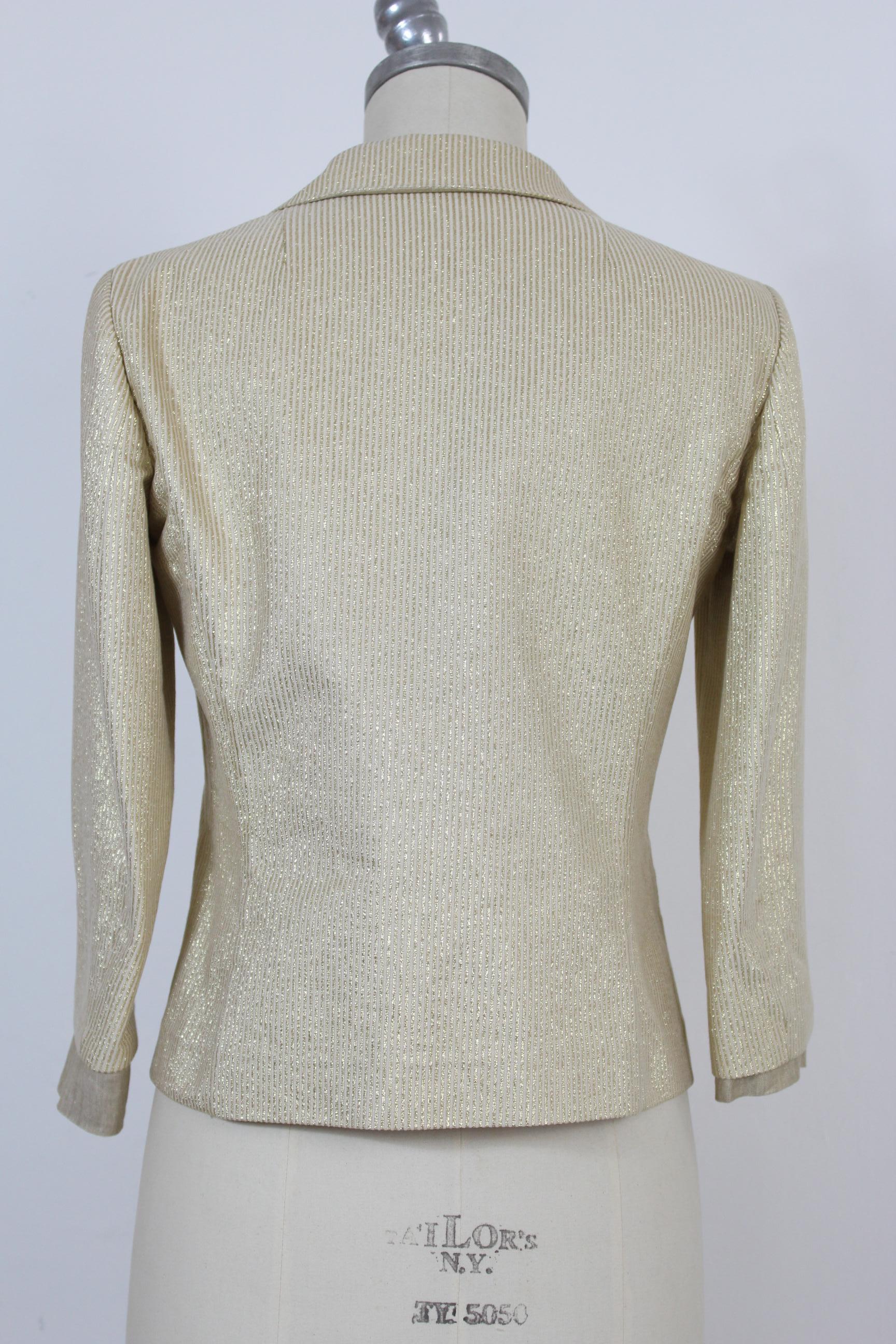 Etro vintage short jacket from the 2000s. Pinstripe, beige, with golden stripes. Pockets and front buttoning, logoed beige buttons. Elegant, 3/4 sleeves with cuff. Composition 56% cotton, 39% polyester, 5% nylon. Lining 53% acetate, 47% polyester.