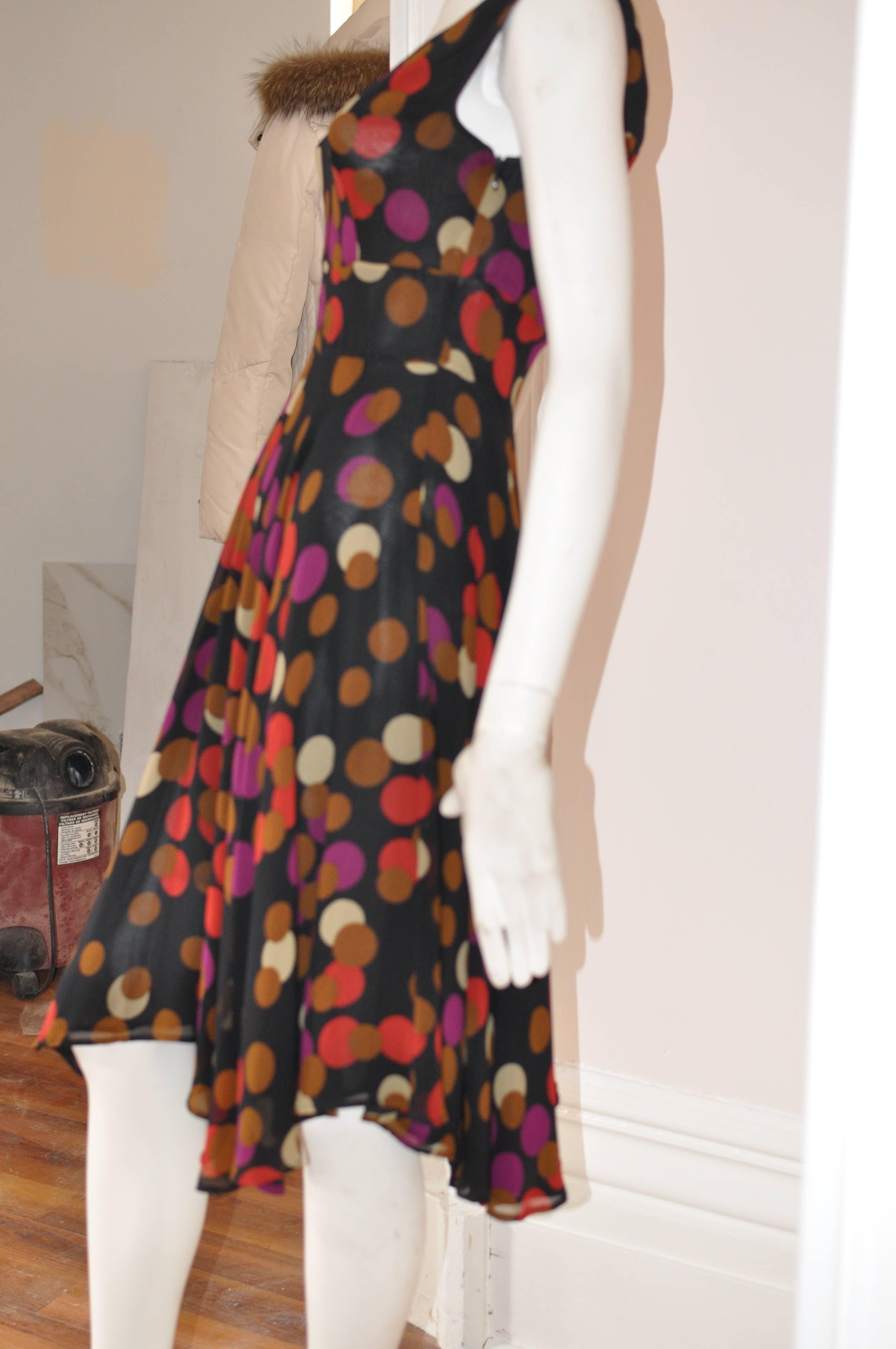 Lovely 100% silk dress with handkerchief hems and fully lined. The dress has a multicolored circle motif on a black background; a defined broad waist band, and a side zip closure.

Can be worn day or evening.