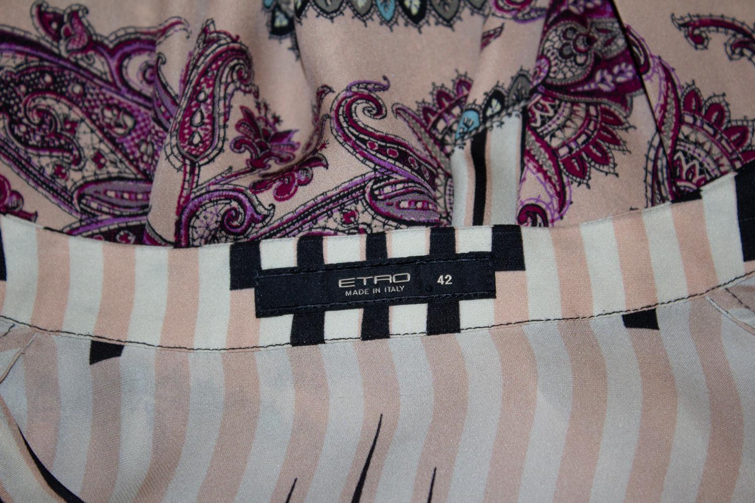 Una meravigliosa camicetta in seta dell'azienda italiana Etro. In un meraviglioso mix di righe e stampe floreali, la blusa è senza colletto con bottoni sul davanti e polsini. 
Prodotto in Italia. Taglia 42 Misure: Busto 41'', lunghezza 31''.