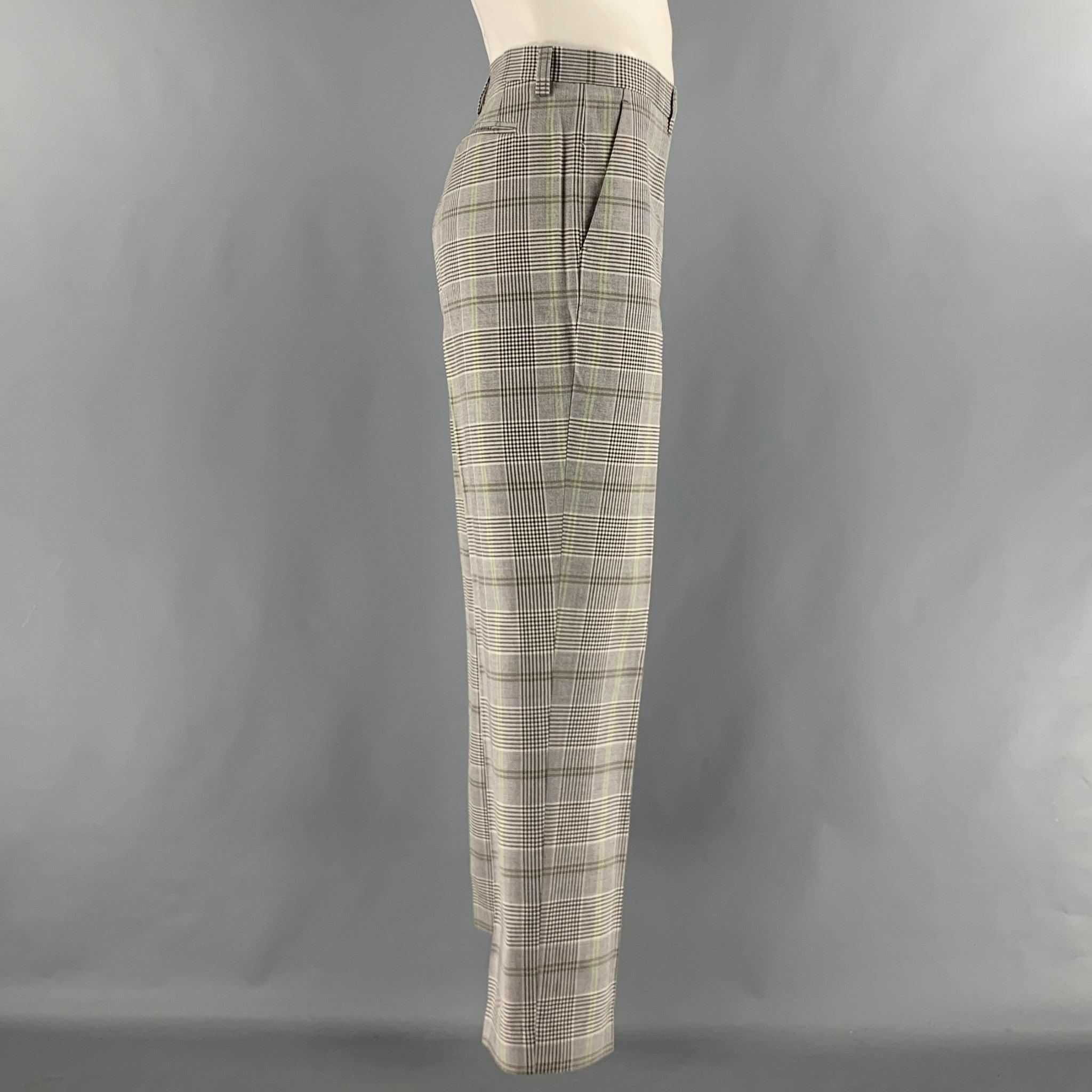 Le pantalon habillé ETRO est en laine tissée à carreaux noirs, blancs et verts. Il présente un devant plat, une coupe régulière, des poches fendues et une fermeture à glissière. Fabriquées en Italie. Très bon état d'origine. 

Marqué :   52