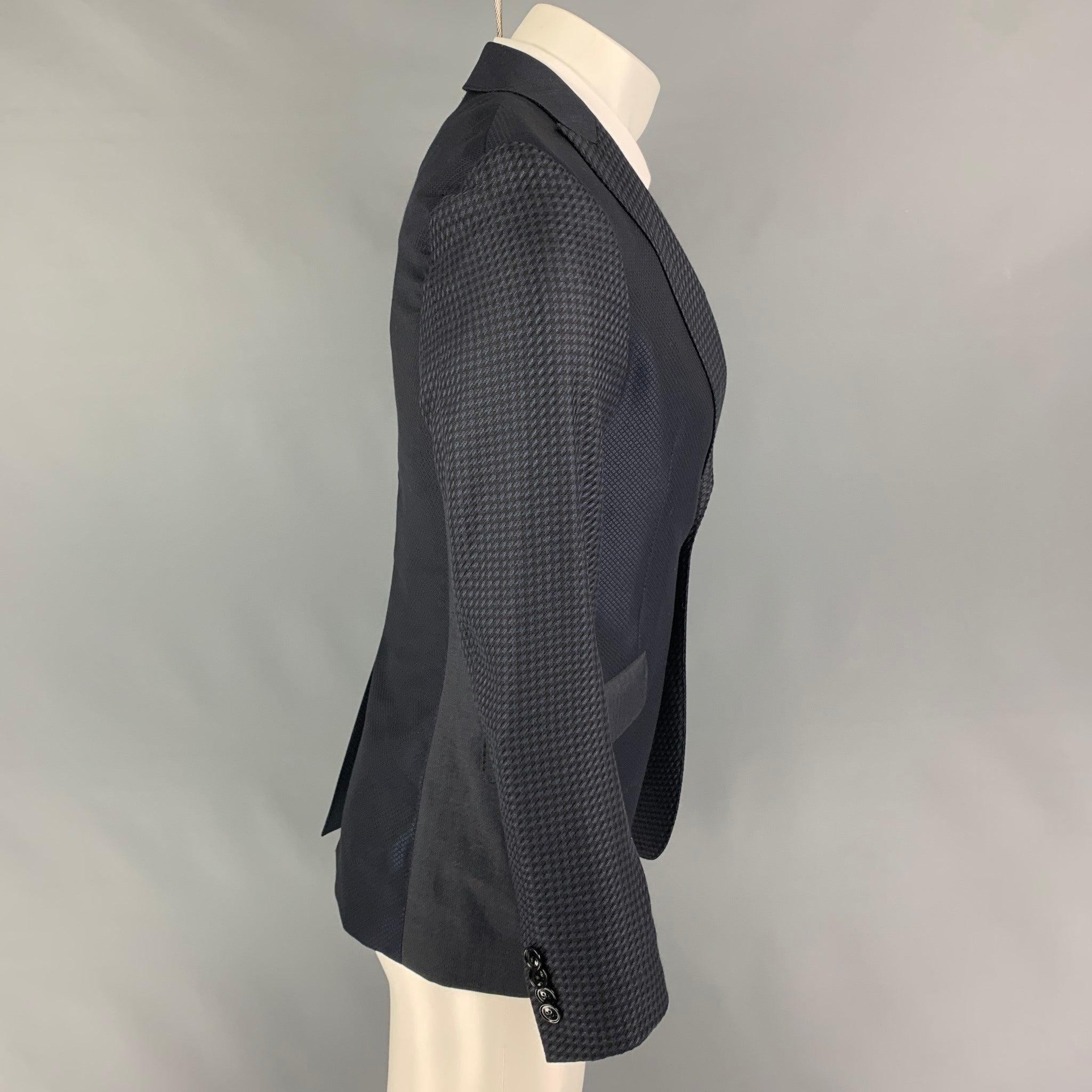 El abrigo sport ETRO se presenta en lana / seda negra y azul marino, con solapa de pico, motivos mixtos, bolsillos con solapa, una sola abertura en la espalda y cierre con doble botón. Fabricado en Italia.
Excelente
Estado usado. 

Marcado:   48