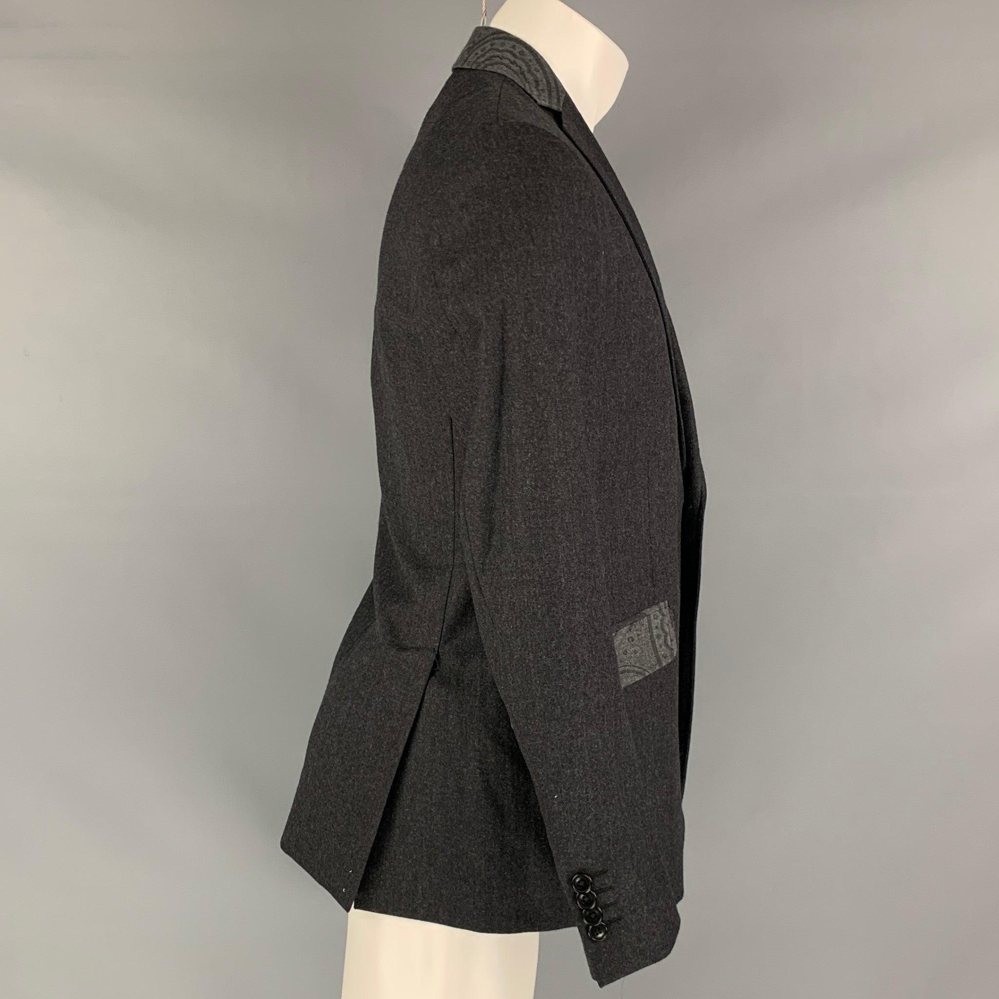 ETRO sport coat comes in a charcoal wool blend woven material with a full liner featuring a notch lapel, flap pockets, double back vent, and a two button closure. Made in Italy.Excellent Pre-Owned Condition. 

Marked:   38 

Measurements: 
