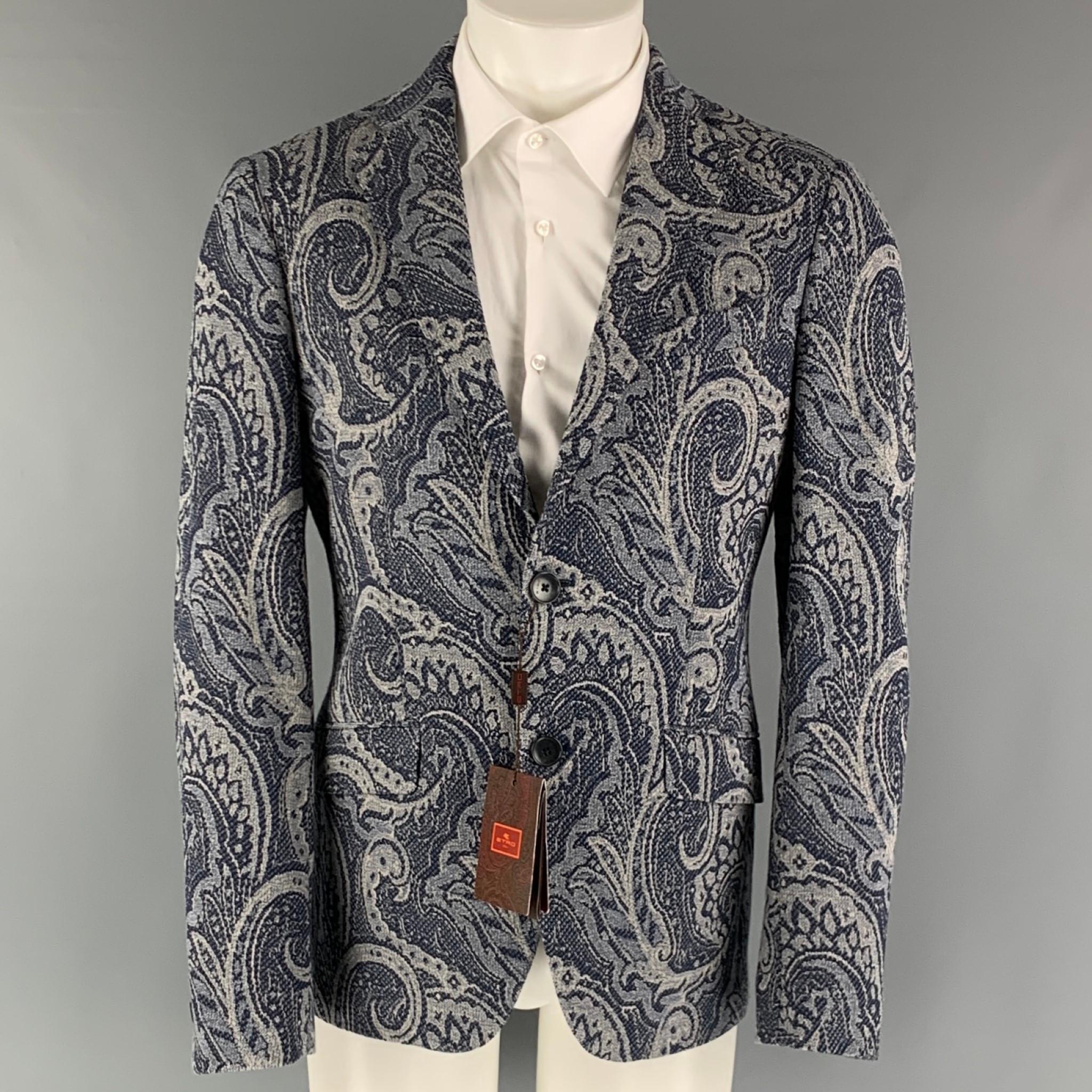 ETRO sport coat comes in a navy and white cotton blend jacquard woven material with a full lining featuring a notch lapel, patch pockets, paisley motif, double back vent, and a two button closure. Made in Italy.

New with Tags.
Marked: IT