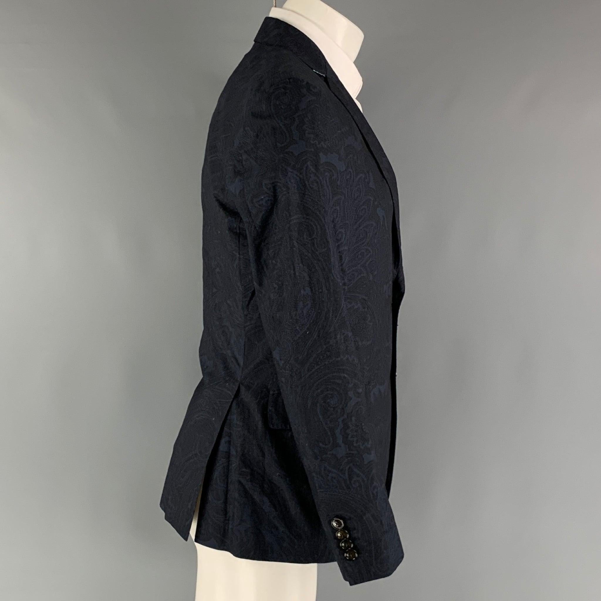 ETRO sport coat comes in a navy paisley cotton woven material with a full liner featuring a notch lapel, flap pockets, double back vent, and a two button closure. Made in Italy.Excellent Pre-Owned Condition. 

Marked:   IT 48 

Measurements: 
