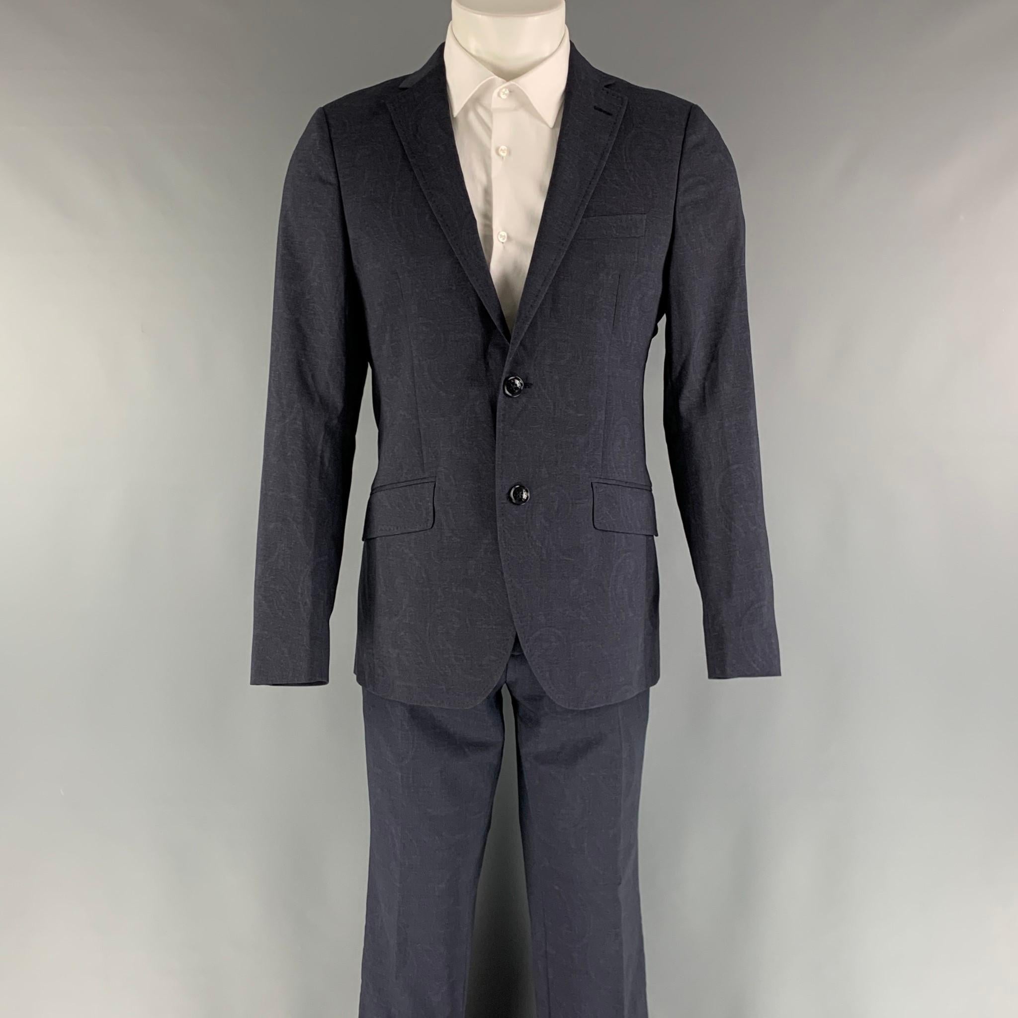 ETRO suit comes in a navy paisley wool and elastane material with a full liner and includes a single breasted, two button sport coat with notch lapel with top stitching and matching flat front trousers. Made in Italy.

Excellent Pre-Owned
