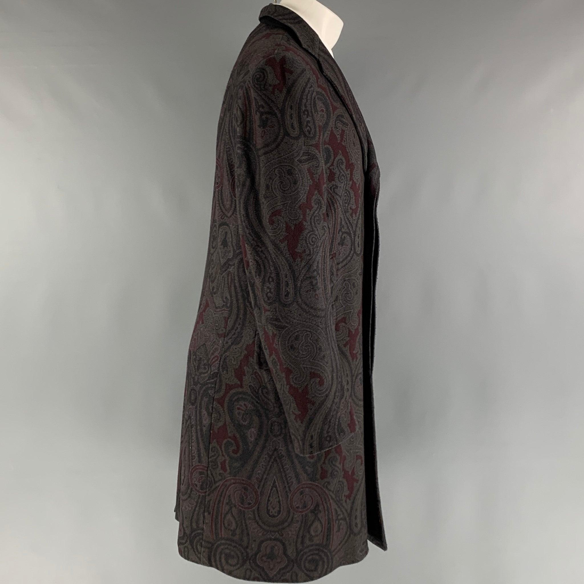 ETRO coat comes in a grey and burgundy wool and polyamide woven material with a full liner featuring a paisley motif, notch lapel, flap pockets, single back vent, and a button closure. Made in Italy.Excellent Pre-Owned Condition. 

Marked:  50