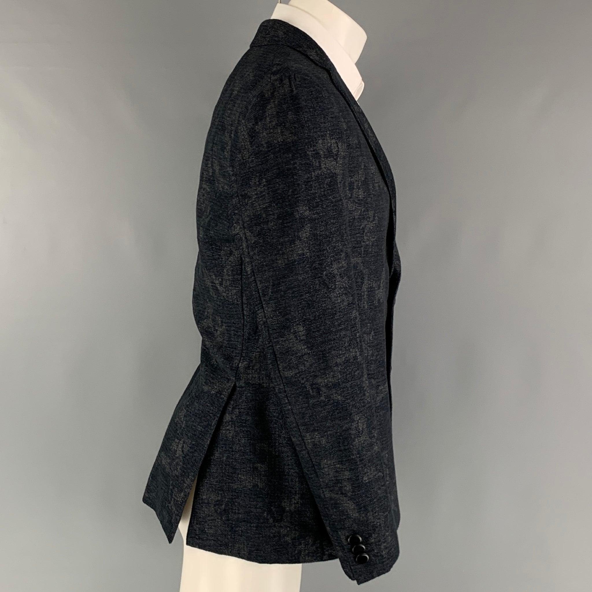 ETRO sport coat comes in a navy and grey jacquard wool and cotton woven material with full lining featuring a notch lapel, patch pockets, double back vent, and a two button closure. Made in Italy.Excellent Pre-Owned Condition. 

Marked:   IT 50