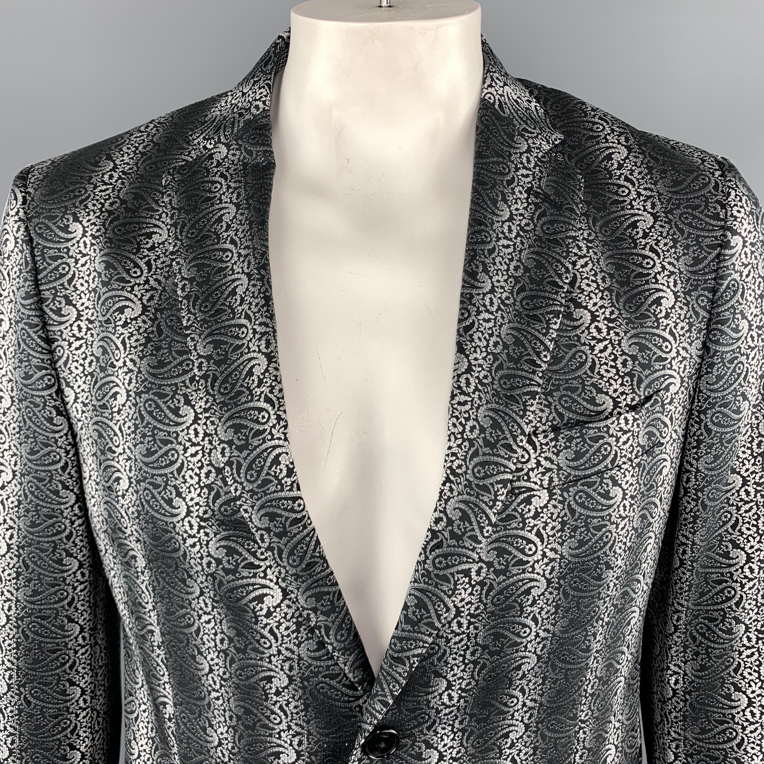 ETRO Sport Coat Jacket comes in black and grey tones in a paisley jacquard polyester blend material, with a notch lapel, two buttons at closure, single breasted, slit and flap pockets, and buttoned cuffs. Made in Italy.

Excellent Pre-Owned