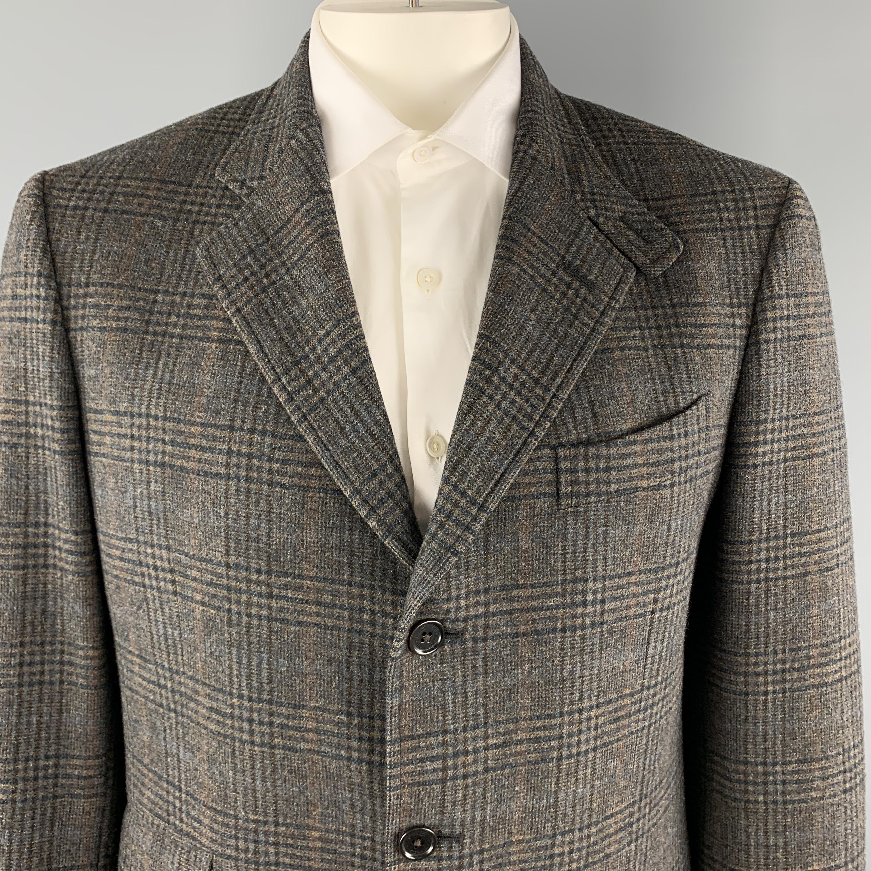 ETRO sport coat comes in a taupe wool cashmere blend with plaid pattern throughout in hues of blue and brown featuring a notch lapel, single breasted, three button front, and purple paisley lined tab collar. Made in Italy.

Excellent Pre-Owned