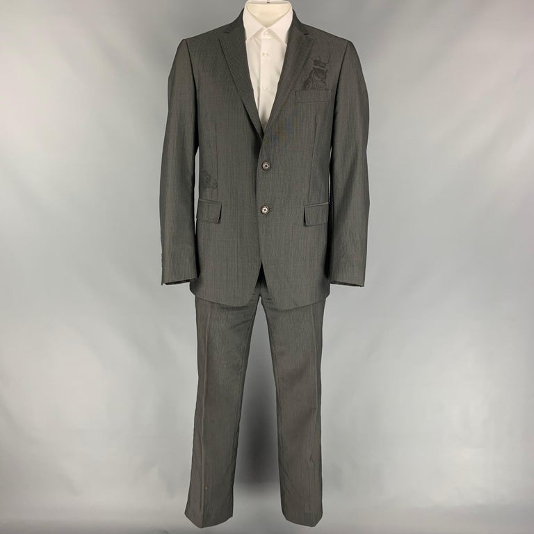 ETRO suit comes in a gray & charcoal stripe wool with a full liner and includes a single breasted, embroidered designs, two button sport coat with notch lapel and matching flat front trousers. Made in Italy.

Very Good Pre-Owned Condition.
Marked: