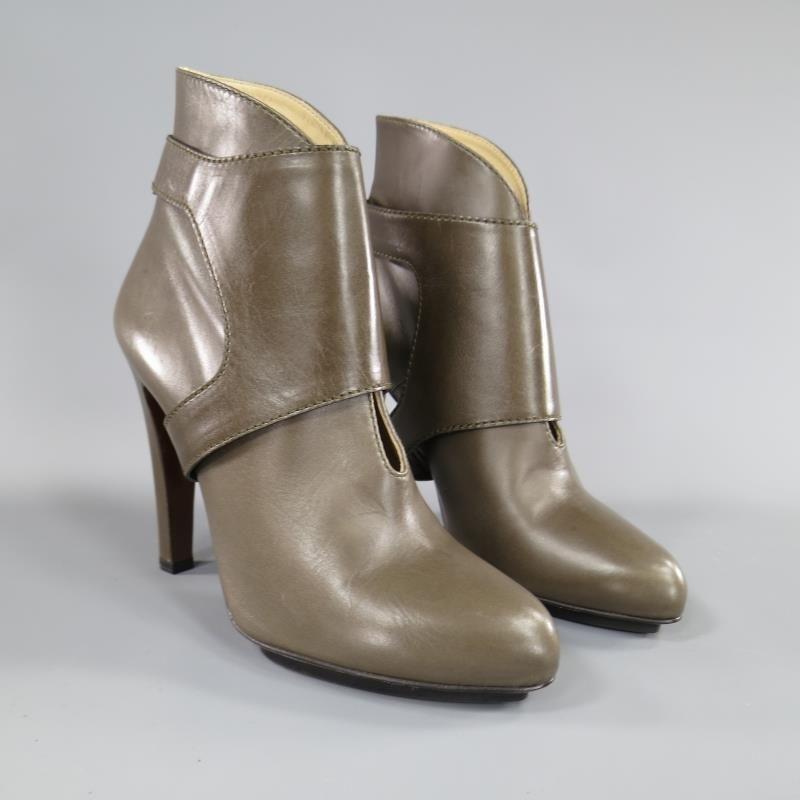 ETRO booties come in a gorgeous neutral taupe olive green smooth leather and feature a frontal slit, covered heel, black platform, and detachable harness. Made in Italy.  Retailed for $1,235.00

New without Tags.

Marked: 39

Measurements:

Heel: 5