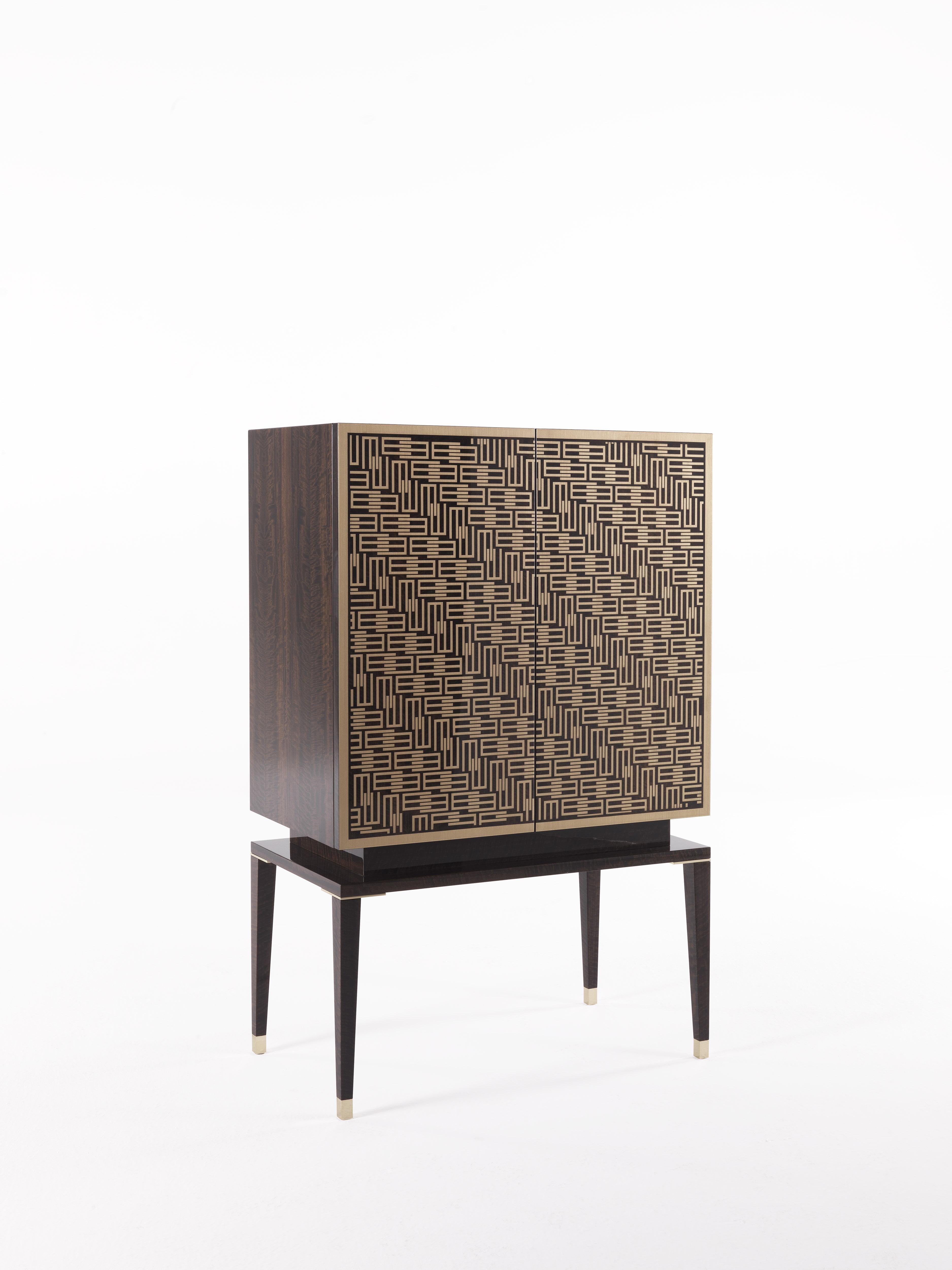 A new, deco style cabinet, characterized by precious inlays in brass with a pattern that incorporates the 