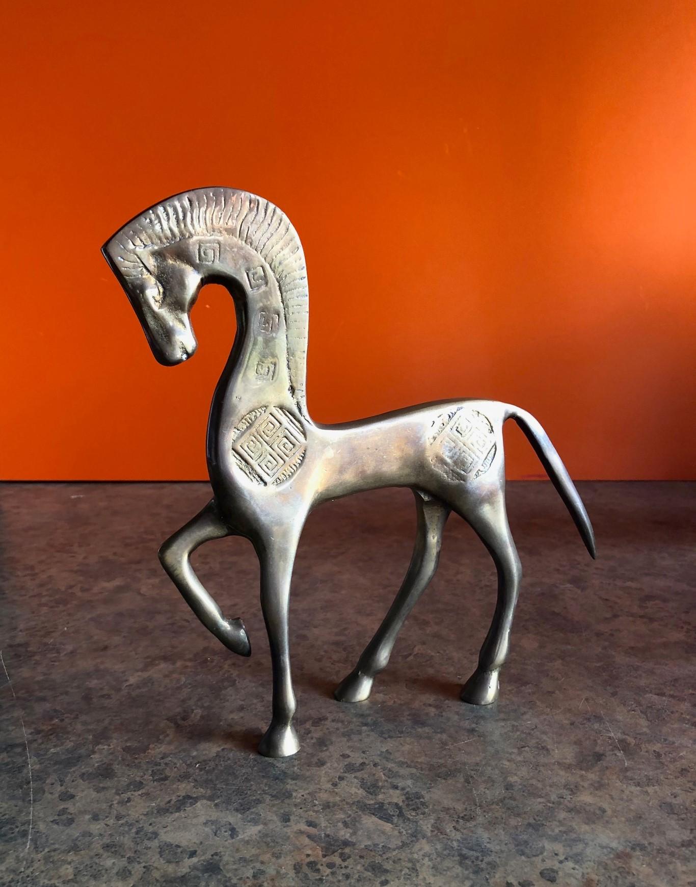 Simple and elegant Etruscan patinated brass horse sculpture in the style of Frederic Weinberg , circa 1970s. 

Minimalist and modern, this piece has nice etched detailing and is perfect for an office or mantel.



 