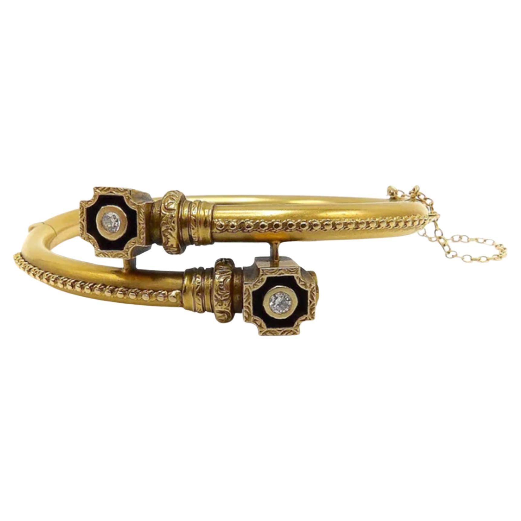 This is a stunning Etruscan Revival bracelet in 14k gold with diamonds and exquisite gold detailing. It features a bypass design with decorative lines of beaded gold granulation that lead up to a crossed shaped shadow box. Inside are bezel set