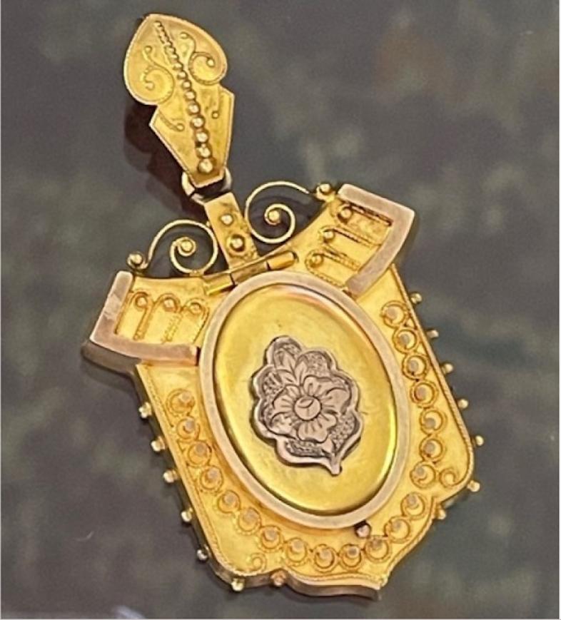 Stunning example of Etruscan Revival craftsmanship, this 15k antique Victorian locket is substantial in size with exquisite details. The center boasts a beautiful rose gold locket door with etched floral motifs. The detail continues on to the ail