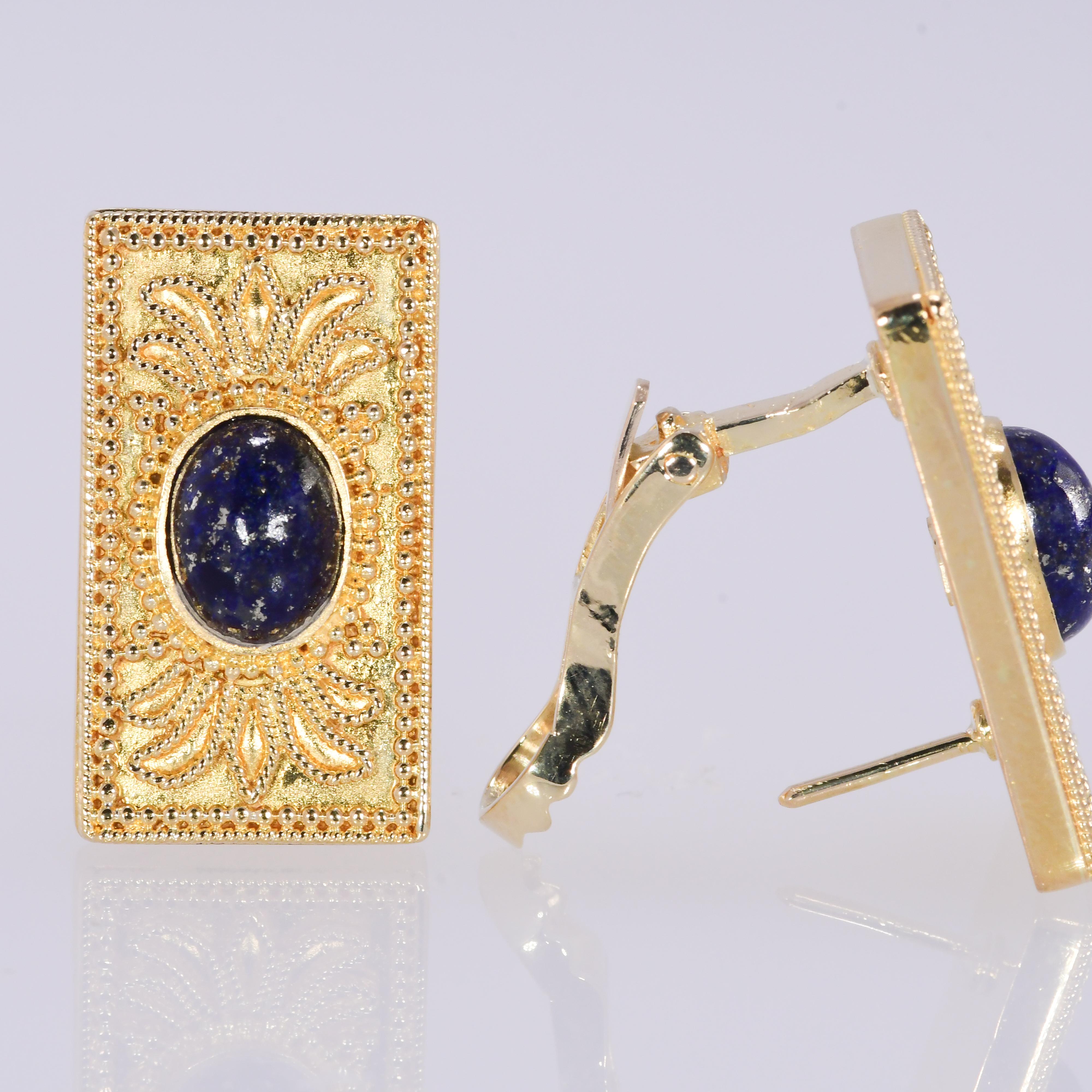 Etruscan revival oval cabochon lapis lazuli earrings. 22 karat yellow gold with 18 karat yellow gold omega backs. A beautiful rectangular shape with intricate design. The length is 11/16 inch. The width is 1/2 inch. The height is 1/8 inch. The