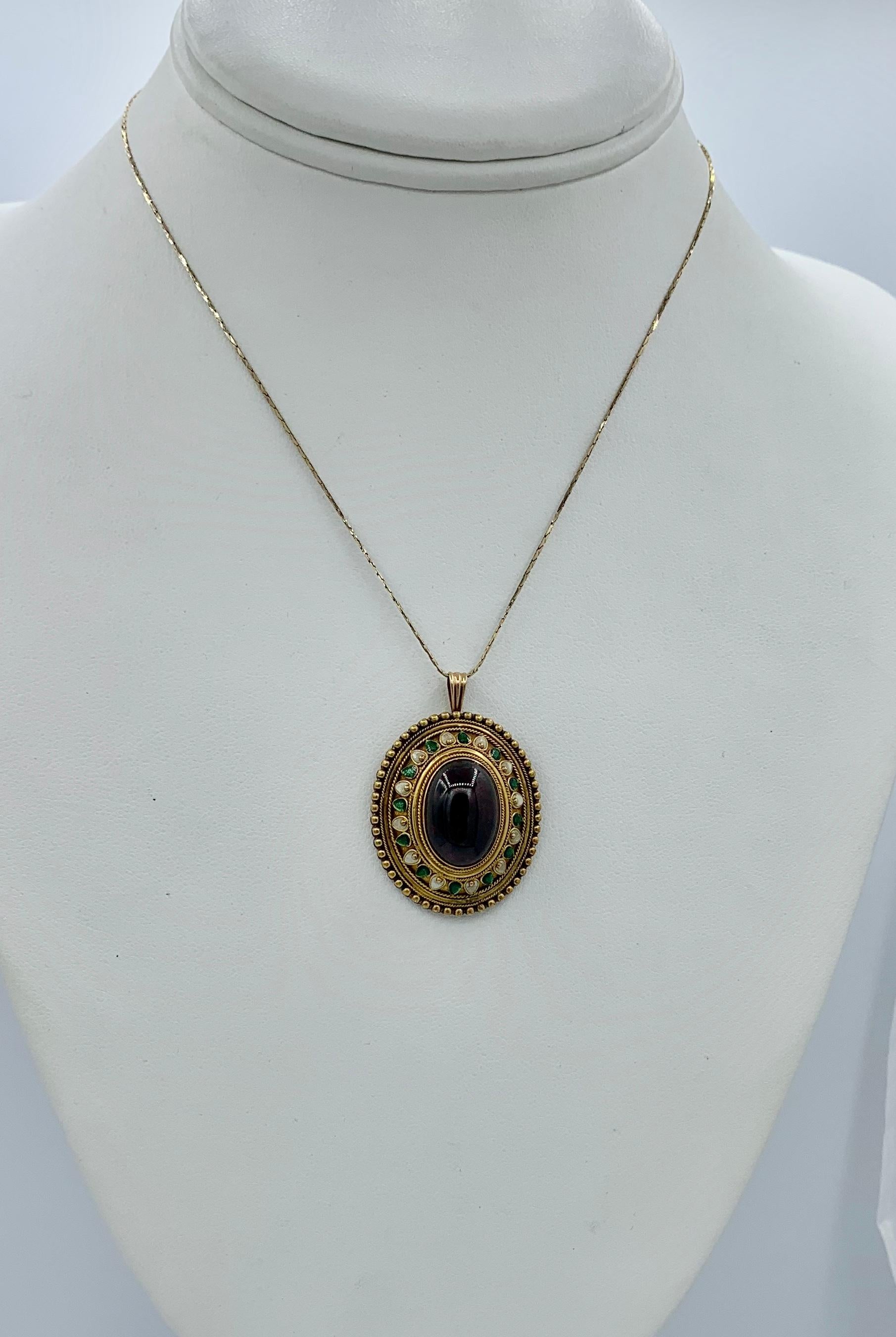 This is one of the most stunning antique 19th Century Garnet Enamel jewels we have seen.  The Etruscan Archeological Revival pendant features a magnificent blood red Bohemian Garnet cabochon of gorgeous color and size set in a 14 Karat Gold Enamel