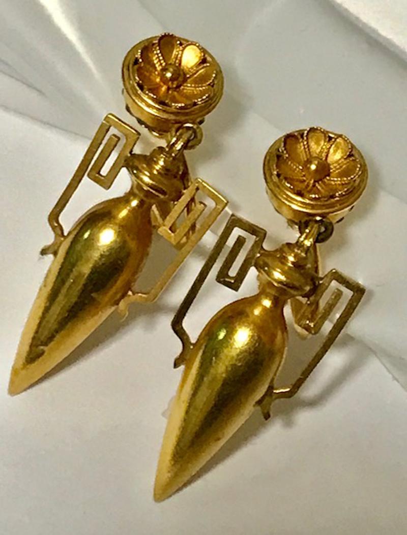Archaeological Etruscan Revival 18-karat gold earrings made in the early 20th century. The pair is composed of amphorae designed with over-sized squared handles and suspended from floret tops. In great antique condition with age-appropriate wear and
