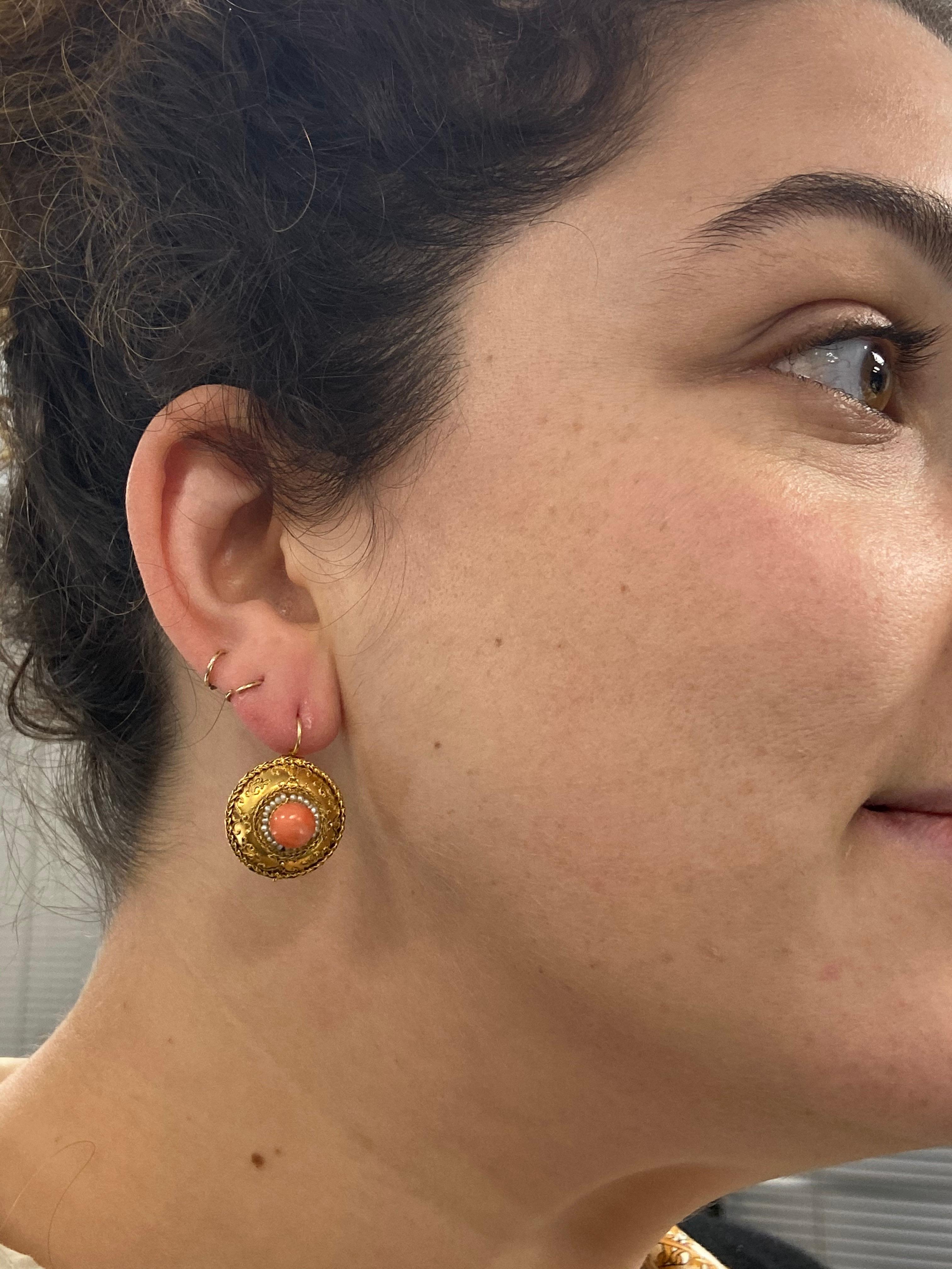 Etruscan Revival Gold Coral and Seed Pearl Pendant Earrings, circa 1860s

These earrings are a lovely example of Etruscan Revival jewelry. They are set with a central cabochon coral in a seed pearl surround to the intricate gold bead frame, circa