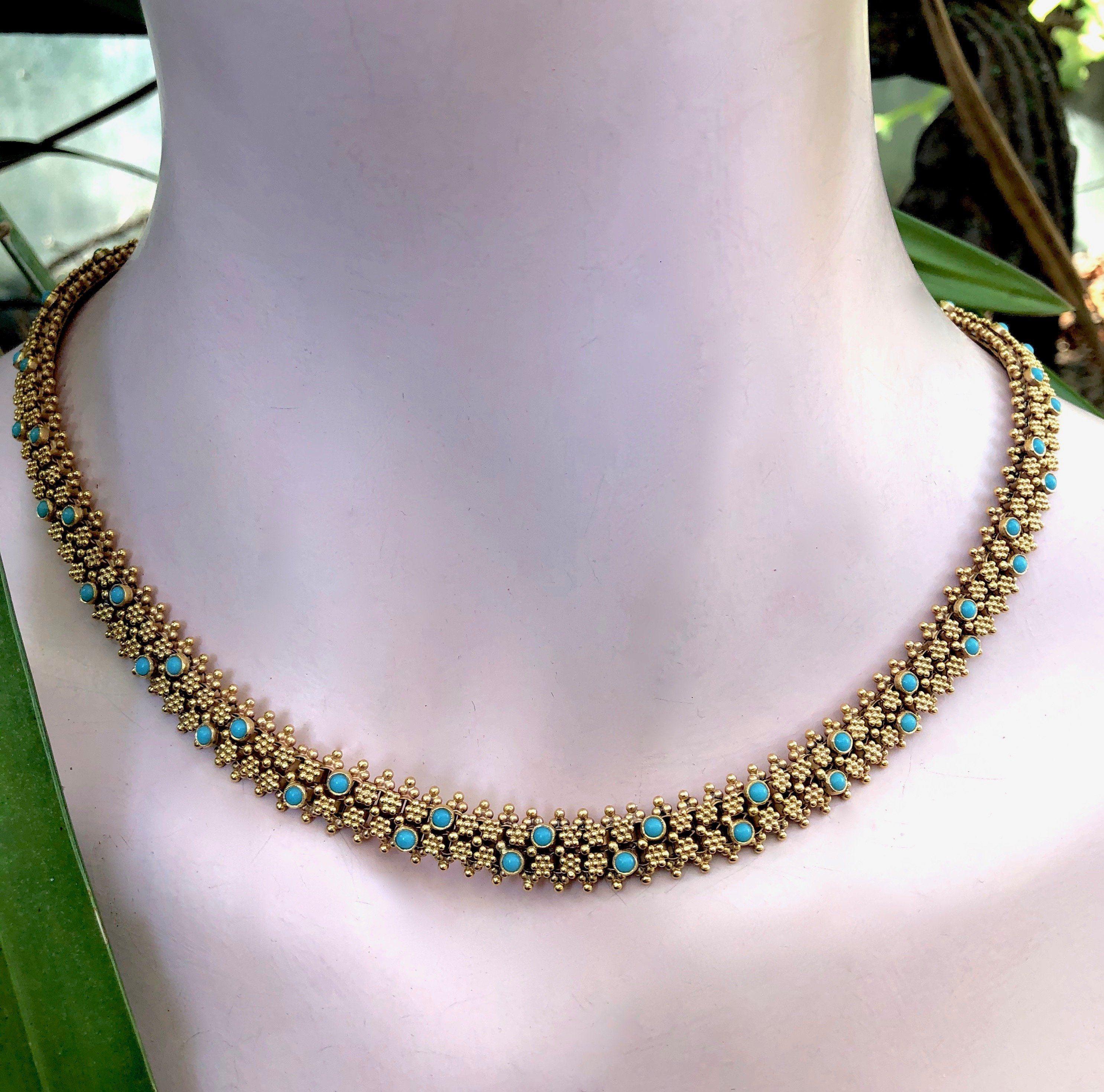 A superb Portuguese necklace with incredible cannetille gold work in 19.2 karats. The necklace has a luxurious design of heavy woven gold that glows from its high karat. It contains over 60 turquoise cabochons and has a flower-like box clasp that