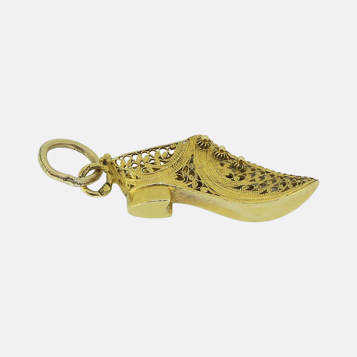 Ecco un delizioso ciondolo vittoriano realizzato in oro giallo 20ct. Questo pezzo è disegnato a forma di scarpa ornata, con un'intricata lavorazione in filigrana e delicati motivi floreali. Il design traforato aggiunge un tocco di eleganza, mettendo