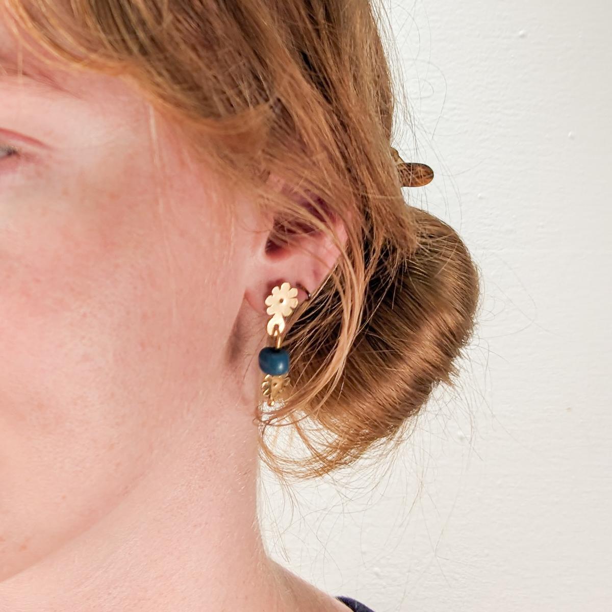 Un bel paio di orecchini in stile Etruscan Revival.

Realizzato dall'orafa modernista di New York Resia Schor. 

In oro 14k.

Composto da elementi ad anello in oro 14k realizzati a mano che sostengono gocce con perle di vetro blu e terminali a