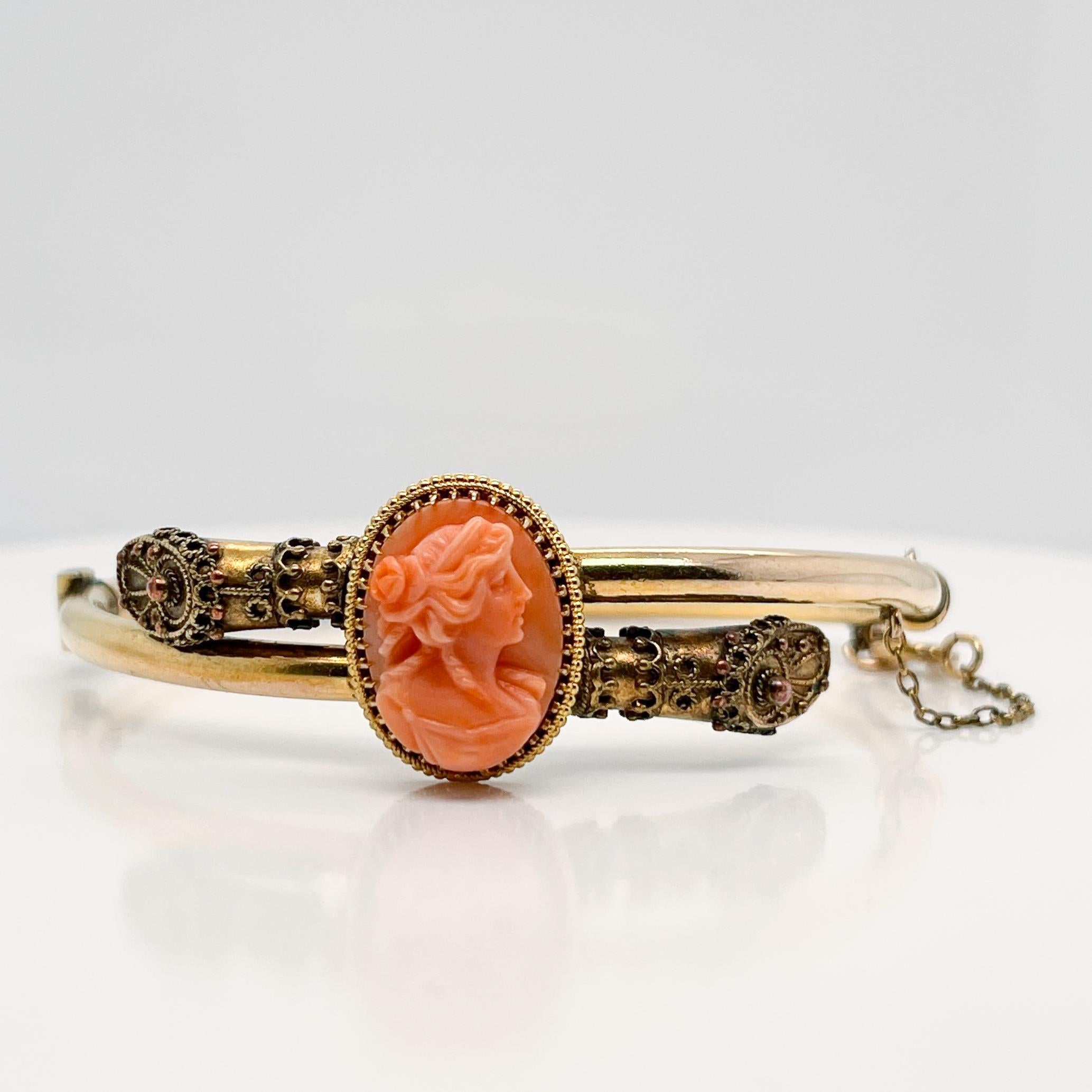 A very fine Etruscan style gold filled bracelet.

The hollow tube bracelet is set with a carved peach colored coral cameo in a decorative gold-filled bezel and is capped with Etruscan Revival style hoof-shaped terminals.

The bracelet opens on a