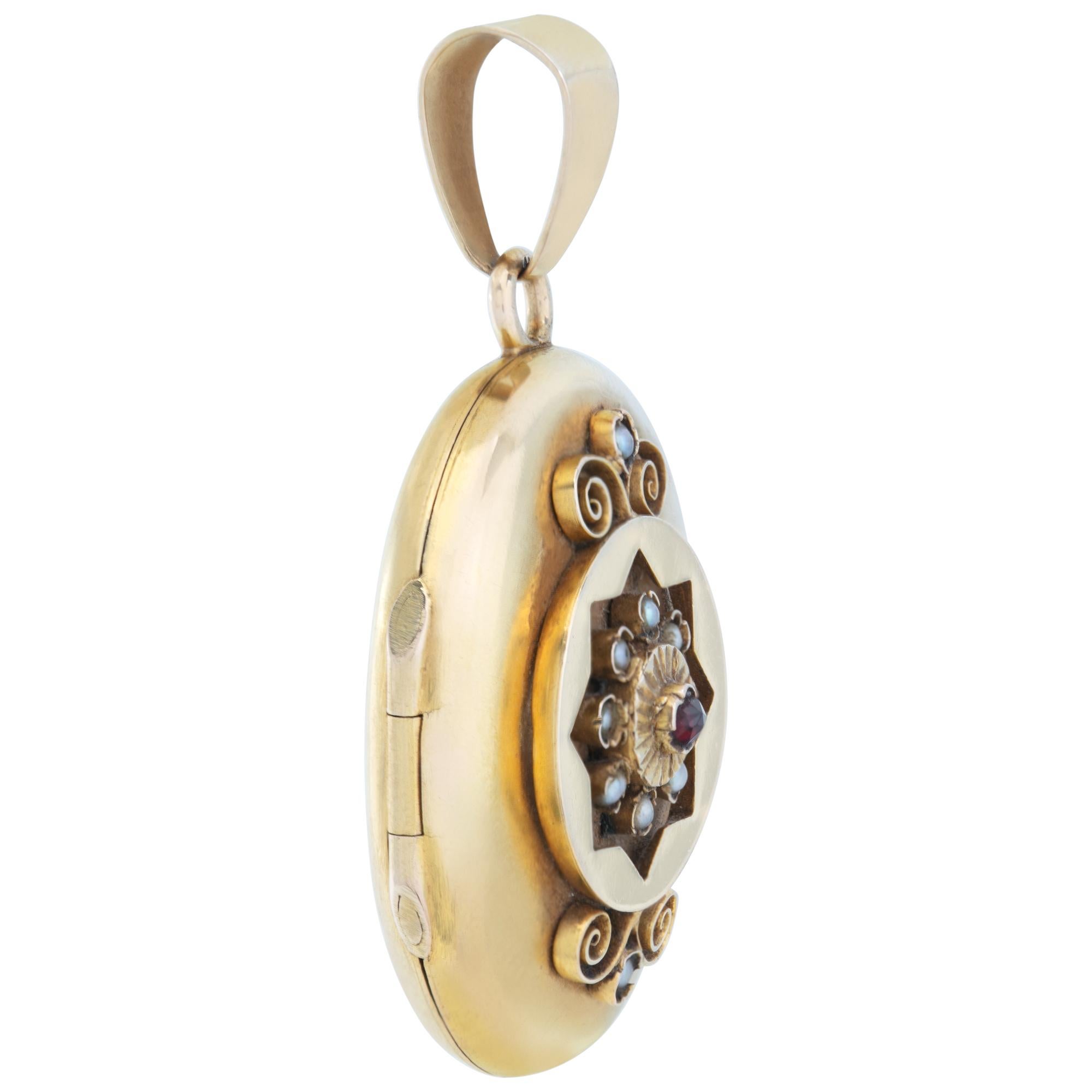 Etruscan Revival  Victorian era locket/pendant in 18k yellow gold. Locket opens to allow a picture to be inserted in. Front cover has 10 seed pearls and a red stone. Total height (including bale): 50mm ( 1 1/4