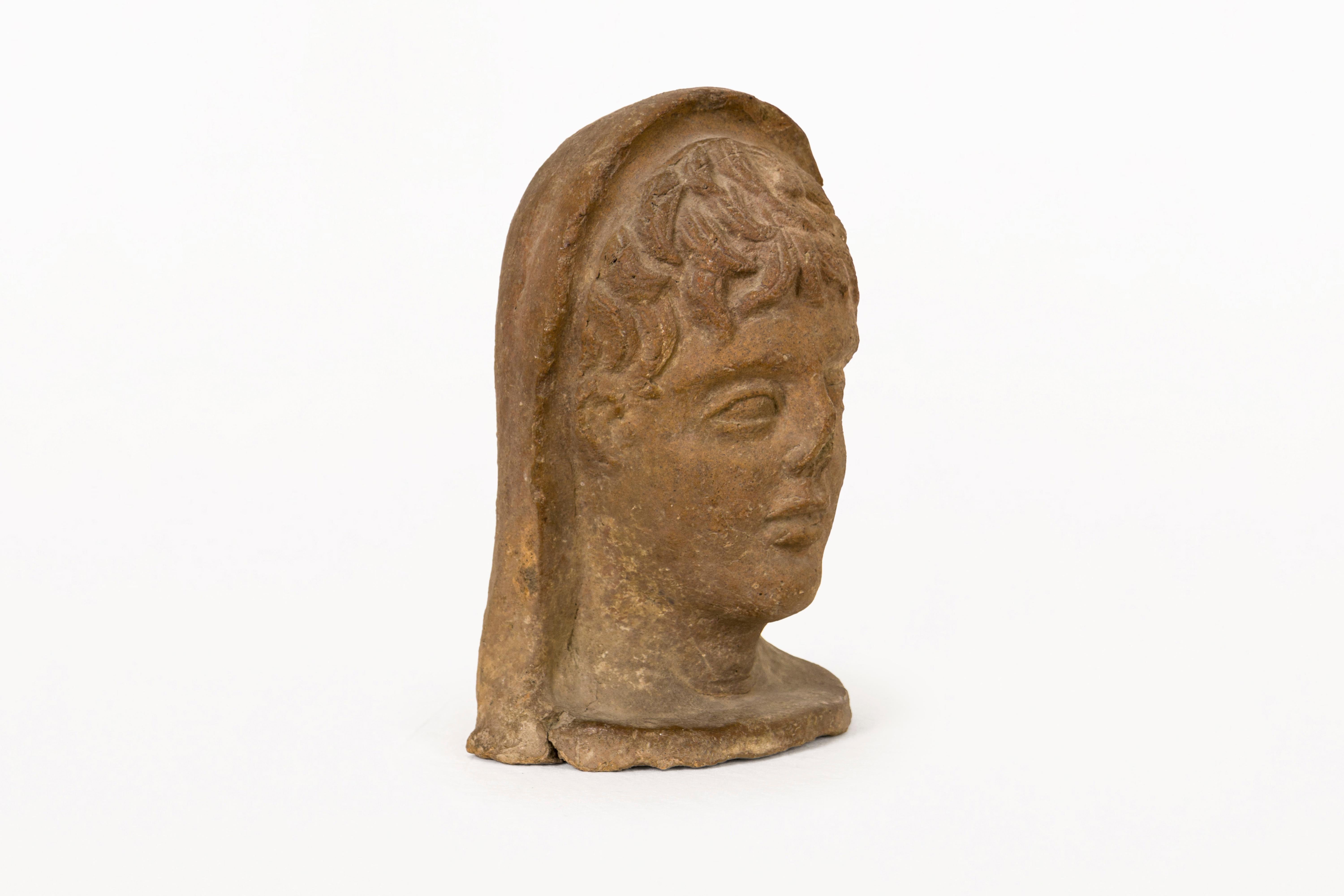 DESCRIPTION :  Tête de sculpture étrusque en terre cuite, l'œuvre représente un jeune homme du IVe siècle. Il s'agit d'une pièce très décorative dont l'état de conservation est bon. Il dispose d'un document de thermoluminescence réalisé dans un