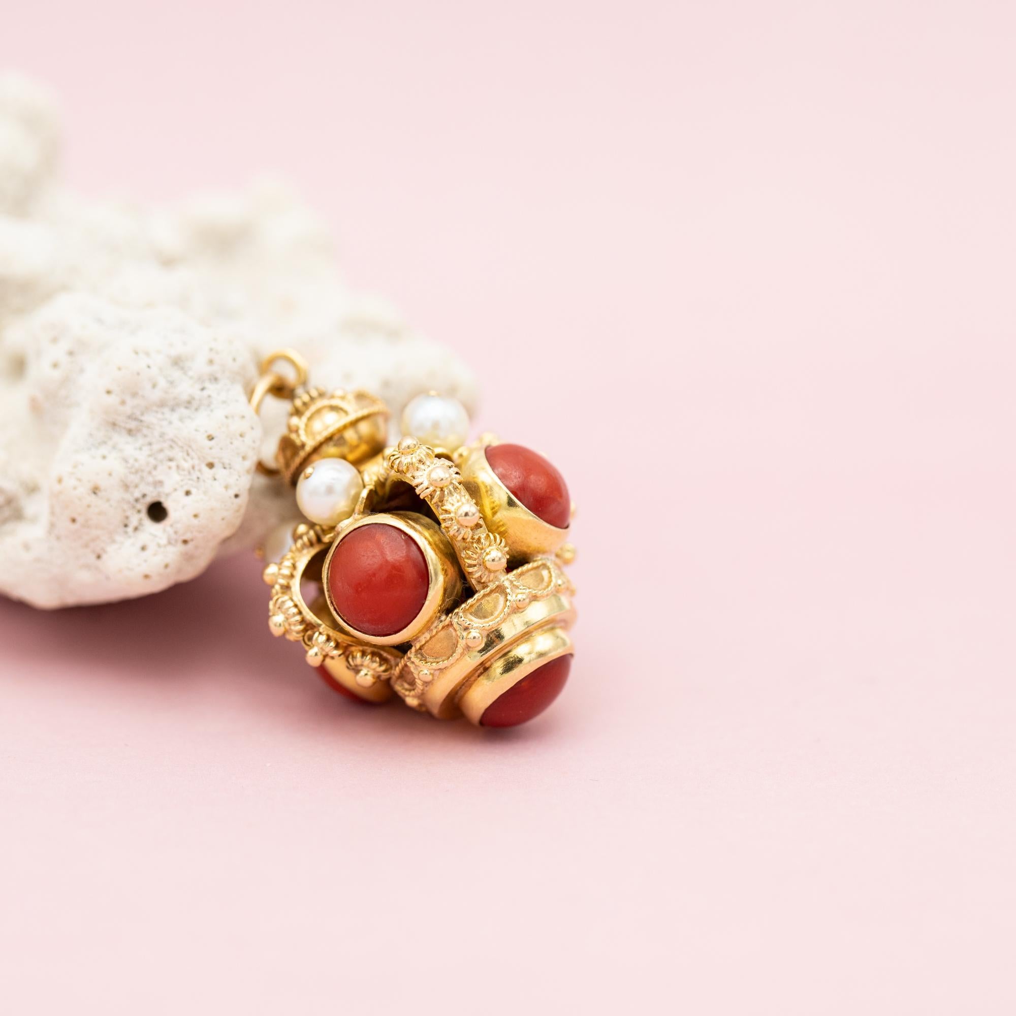 For sale is this wonderful pendant with stunning bright colours thanks to the lovely red coral and elegant white pearls. This vintage charm is intricately detailed, which we like a lot, and features five coral cabochons and four pearls. This