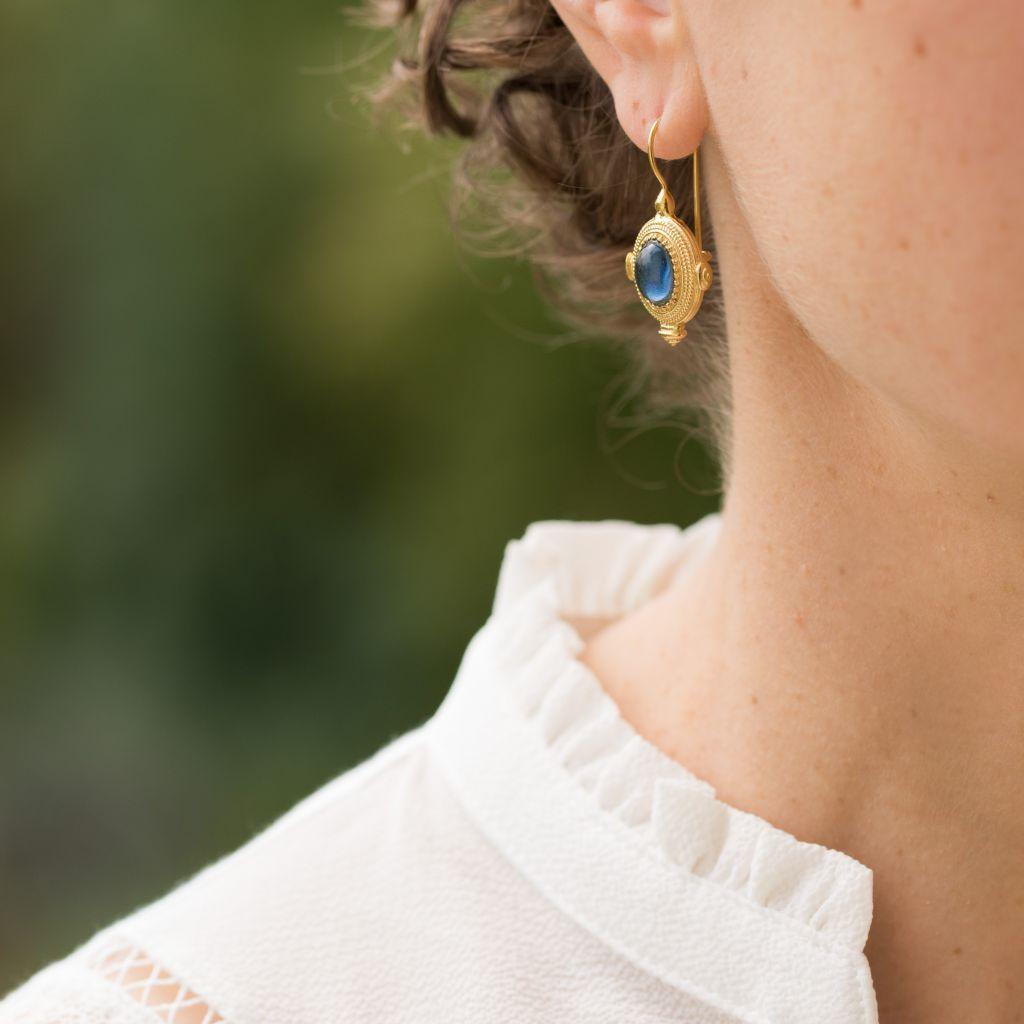 For pierced ears.
Pair of earrings in silver and yellow gold.
 They are set with a blue cabochon stone on a chiseled motif.
The hanging system is a swan neck with safety hook.
Length: 3.4 cm, width: 2 cm
New jewelry from Italian designer Marcello