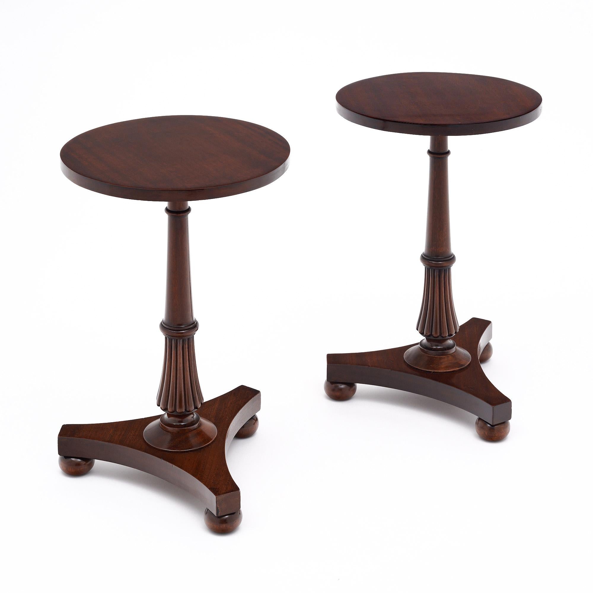 Side tables from the Art Deco period in France. This pair is in excellent vintage condition and made of solid mahogany construction. They have been finished with a lustrous museum-quality French polish. They have a circular top; hand carved
