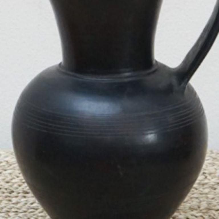Ein schöner, schwarzer Bucchero-Krug im etruskischen Stil. Bucchero ist eine Klasse von Keramiken, die in Mittelitalien in den Regionen der vorrömischen etruskischen Bevölkerung hergestellt wurden, und leitet sich vom lateinischen Wort für